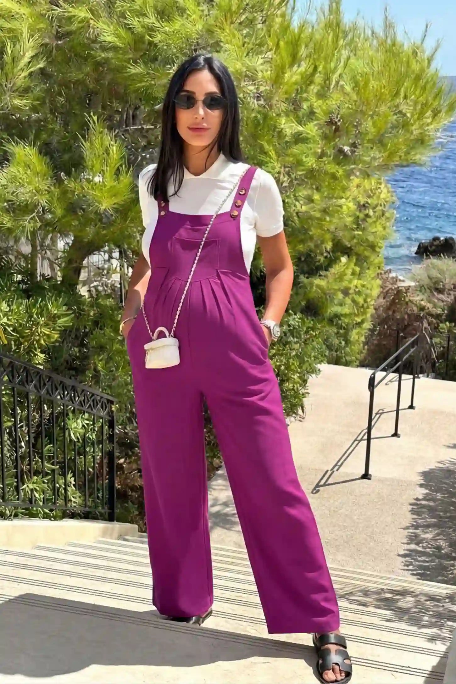 Full-Length Pocketed Maternity Jumpsuit Full-Length Pocketed Maternity Jumpsuit in Wine Red featuring adjustable straps and a relaxed fit on a pregnant model, front view.