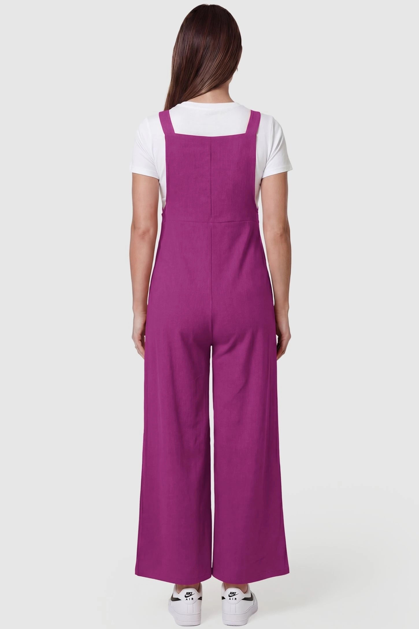 Full-Length Pocketed Maternity Jumpsuit Full-Length Pocketed Maternity Jumpsuit in Wine Red featuring relaxed fit on a pregnant model, back view.