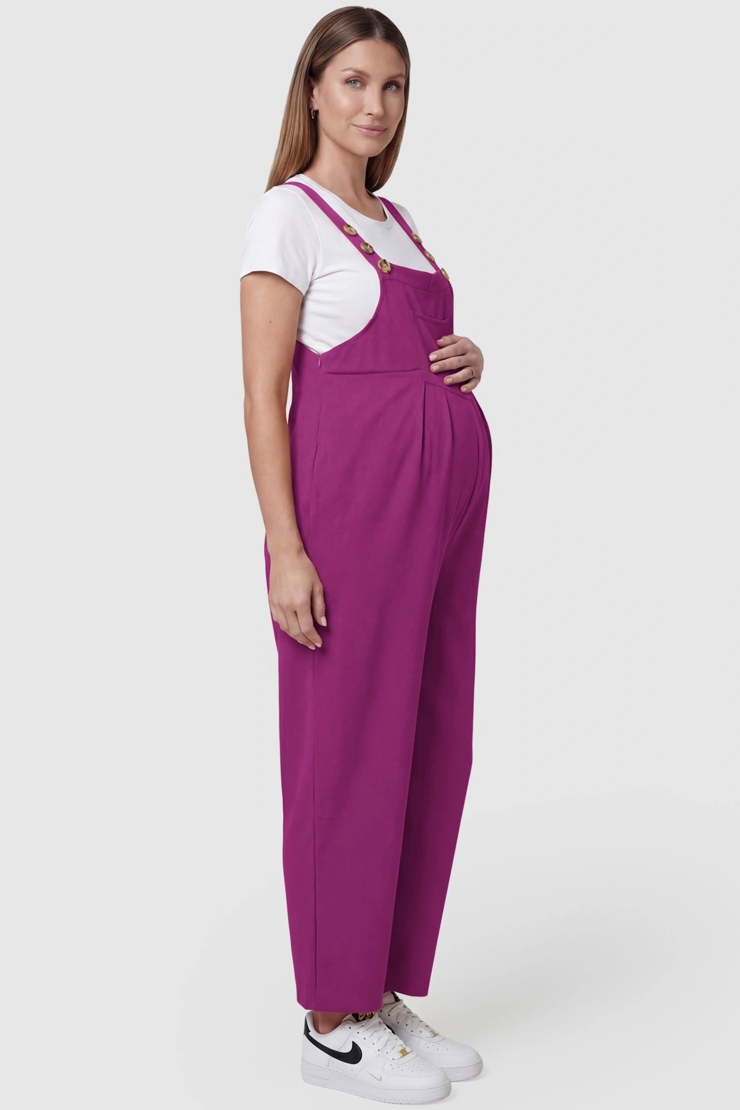 Full-Length Pocketed Maternity Jumpsuit Full-Length Pocketed Maternity Jumpsuit in Wine Red featuring adjustable straps and a relaxed fit on a pregnant model, side view.