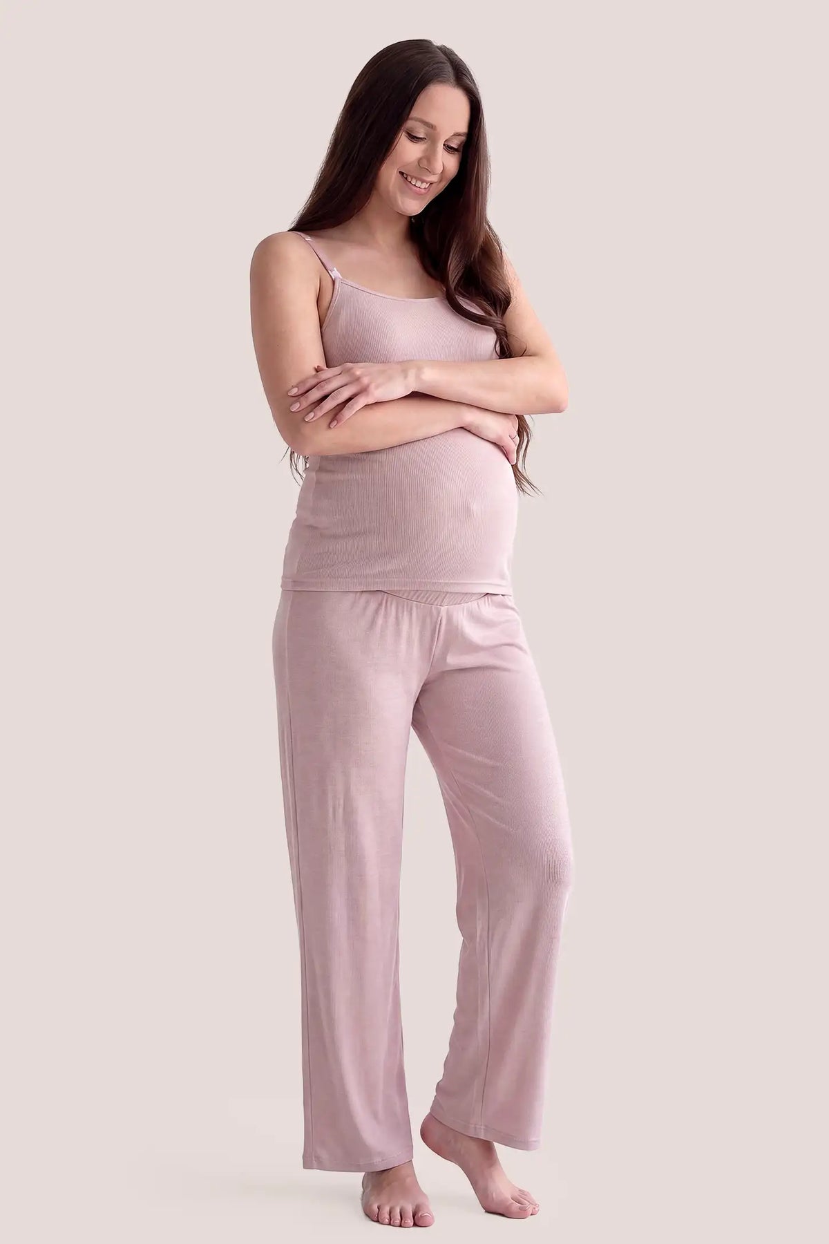 Soft Rib Knit Maternity & Nursing PJ Set with Cami, Cardigan & Pants Soft Rib Knit Maternity & Nursing Pajama Set with Cami, Cardigan & Pants in Soft Pink featuring loose full-length pajama pants, soft rib knit texture, and relaxed maternity fit on a pregnant model, full body view.