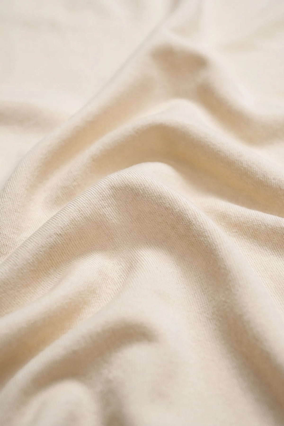 Solid Round Neck Short Sleeve Maternity Top Solid Round Neck Short Sleeve Maternity Top in Beige featuring a close-up view of the soft-touch fabric texture and smooth material finish.