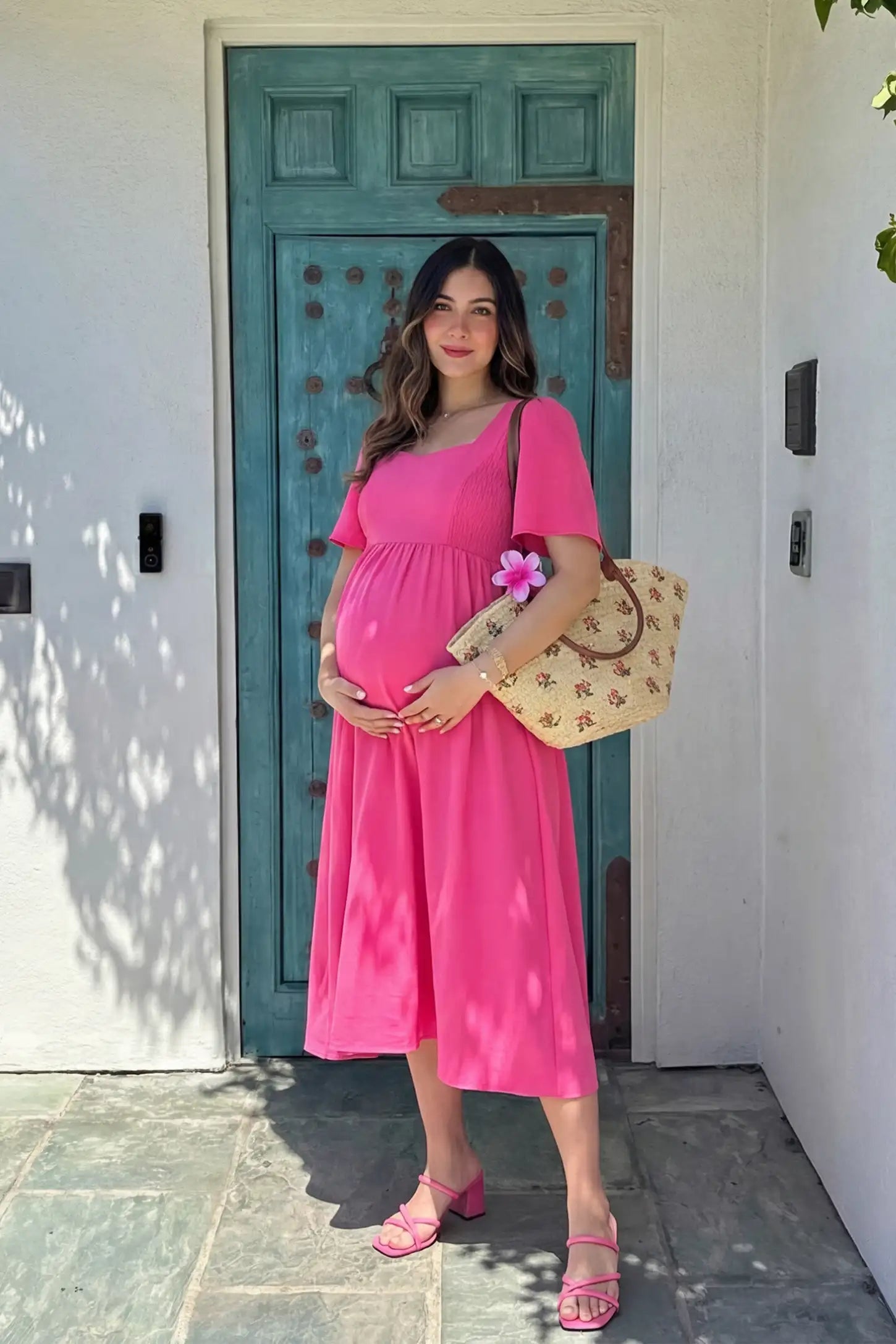 Square Neck Flutter Sleeve A-Line Maternity Midi Dress in rose red featuring flowing silhouette in full body view on a editorial lifestyle model