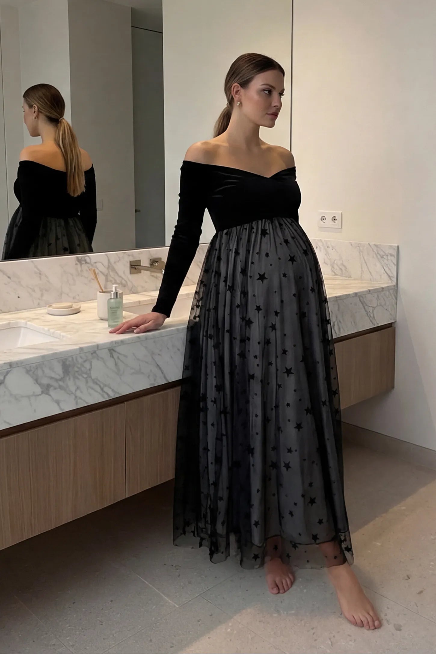 Stars Tulle Long Sleeve Maternity Gown Stars Tulle Long Sleeve Maternity Gown in black featuring velvet bodice and A-line tulle skirt on a pregnant model.