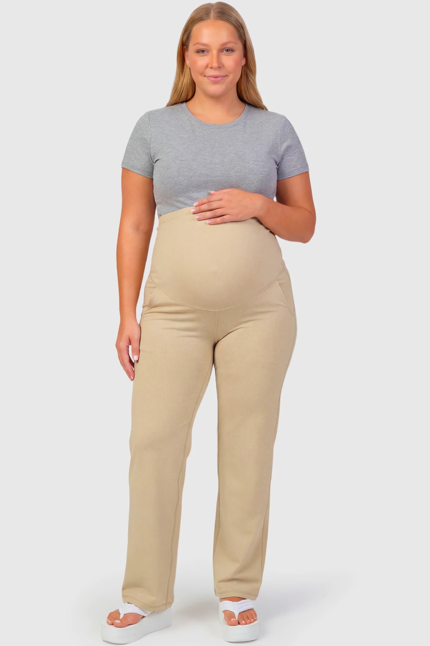 High-Waisted Straight-Leg Maternity Pants High Waisted Straight-Leg Maternity Pants in beige featuring over-the-belly support and standard length fit on plus size pregnant model.
