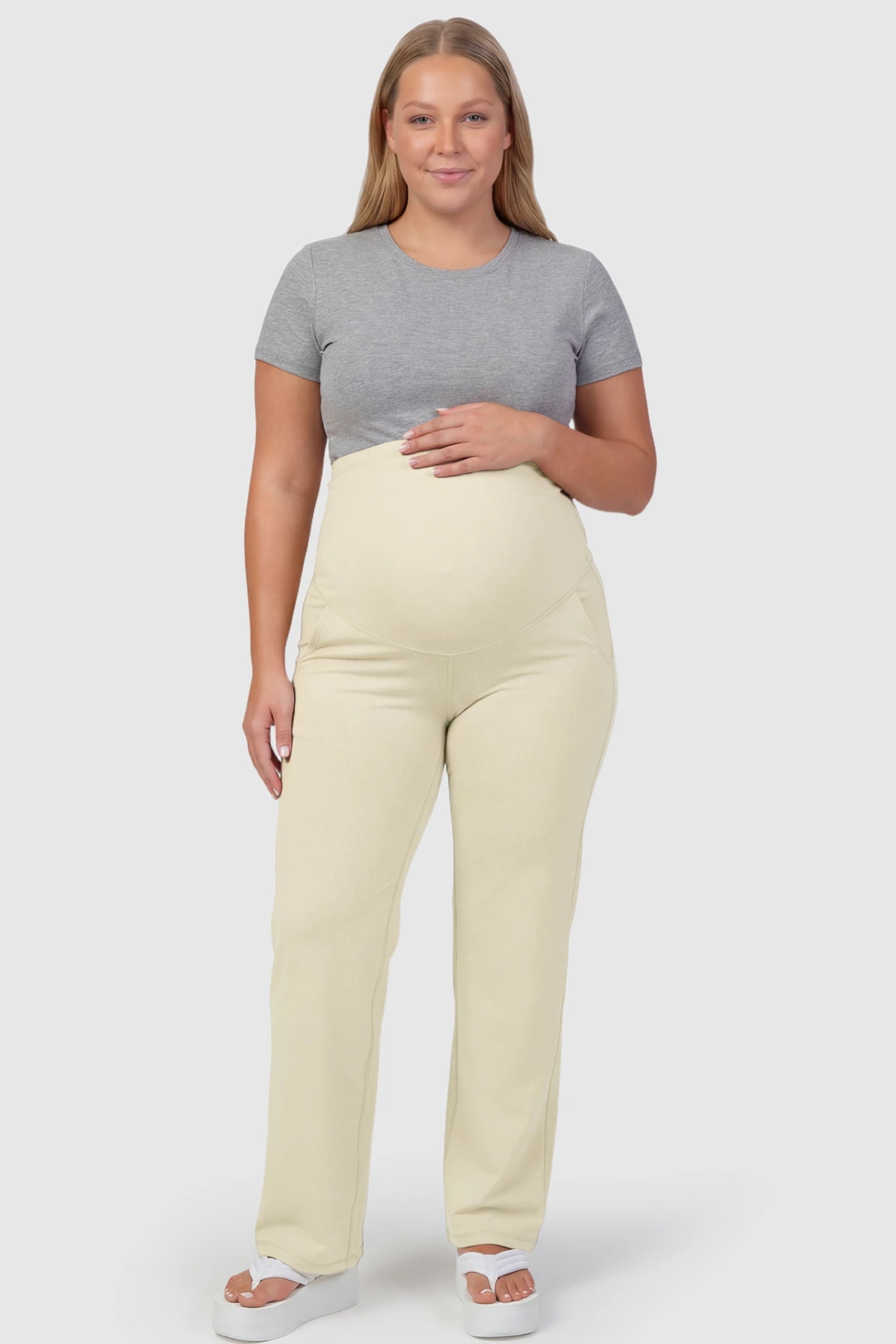 High-Waisted Straight-Leg Maternity Pants High Waisted Straight-Leg Maternity Pants in beige featuring over-the-belly support and standard length fit on plus size pregnant model front view.