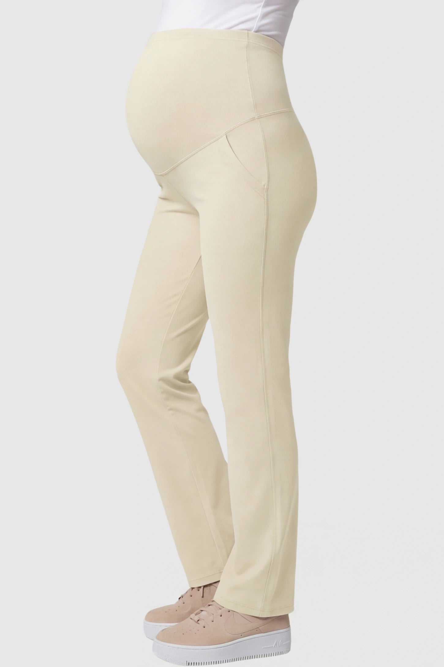High-Waisted Straight-Leg Maternity Pants High Waisted Straight-Leg Maternity Pants in beige featuring over-the-belly support and standard length fit on pregnant model side view.