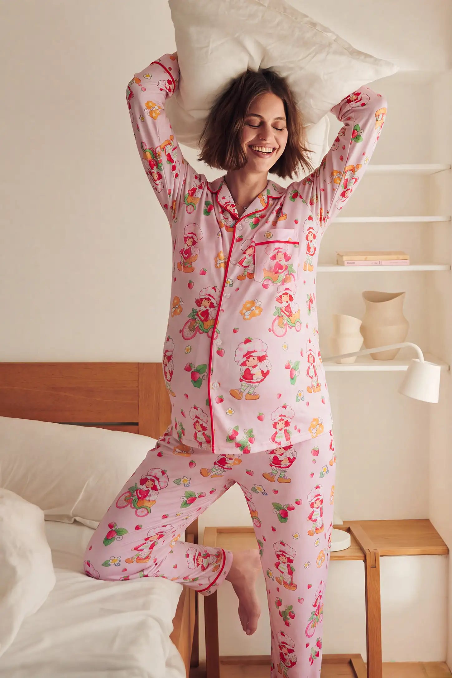 Strawberry Girl Print Satin Long Sleeve PJ Set in Strawberry Girl featuring a long sleeve button-up top, playful strawberry graphics, and cozy nightwear comfort, bedroom pillow pose view.