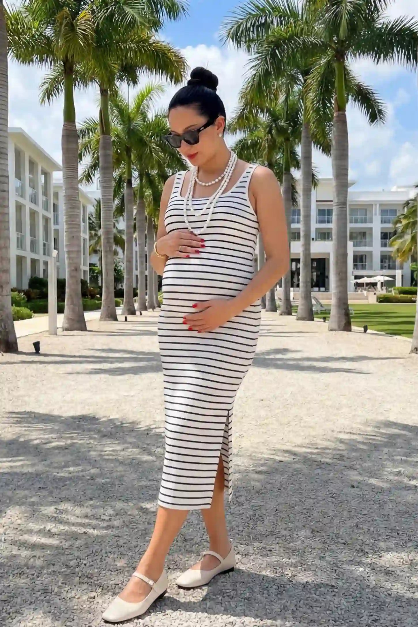 Striped Spaghetti Strap Side Slit Midi Maternity Dress Striped spaghetti strap side slit midi maternity dress in white featuring classic black-and-white stripes in front view on a pregnant model