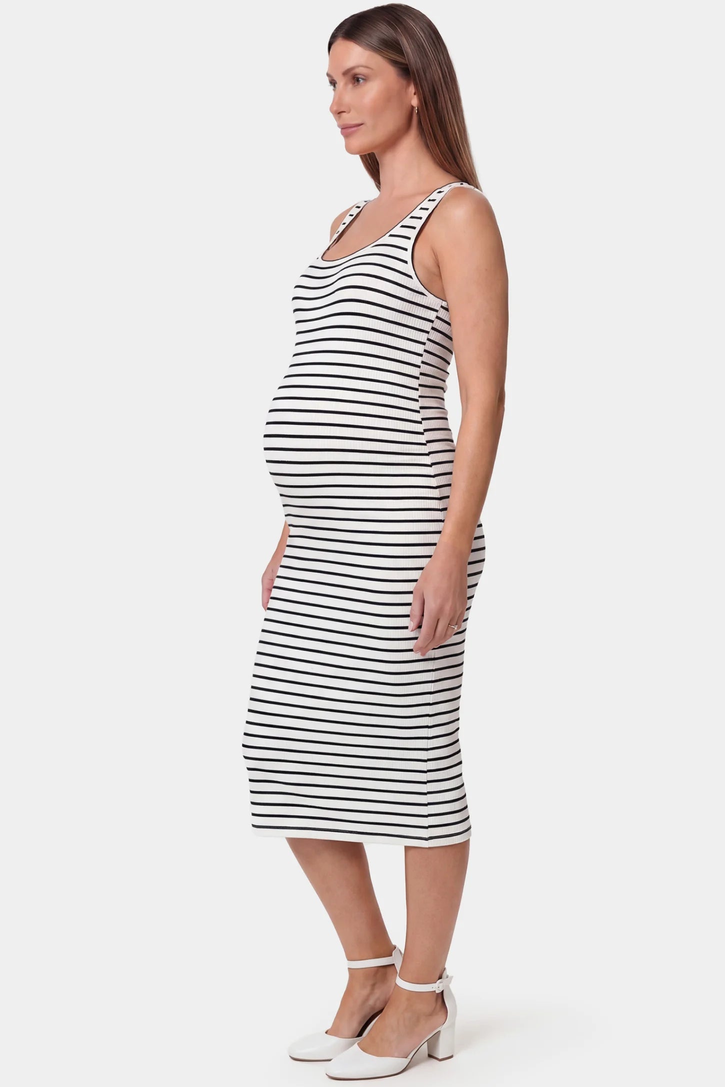 Striped spaghetti strap side slit midi maternity dress in white featuring sleeveless cut in side view on a pregnant model