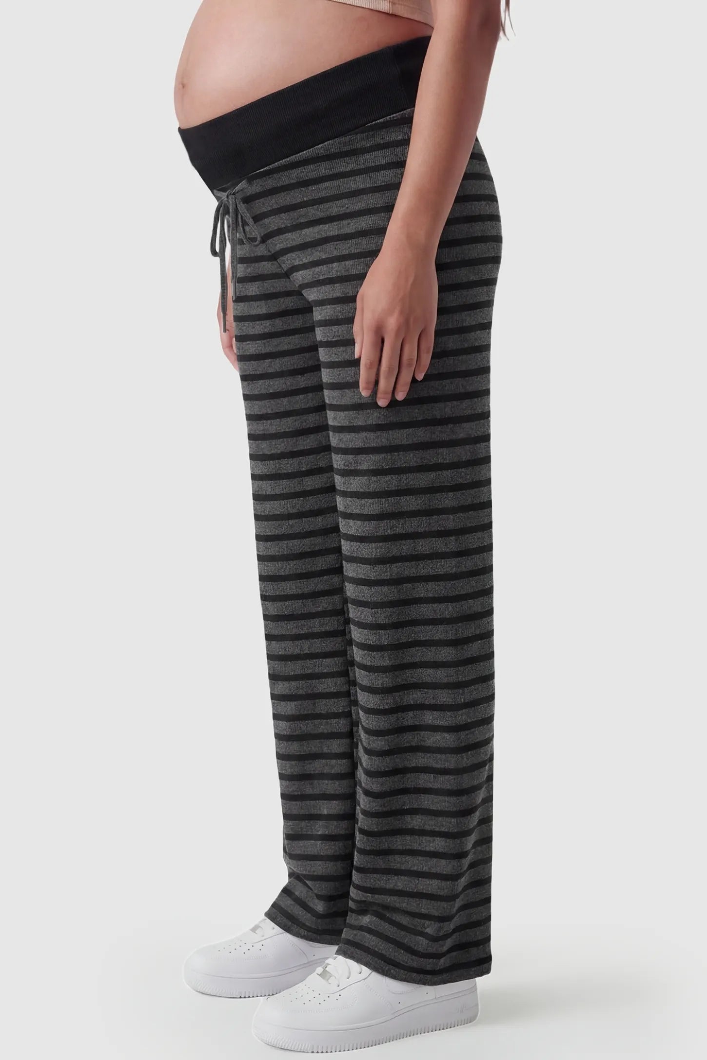 Striped Knit Drawstring Wide-Leg Maternity Pants Striped Knit Drawstring Wide-Leg Maternity Pants in dark gray stripes featuring a curve-accommodating silhouette on a pregnant model, side view.