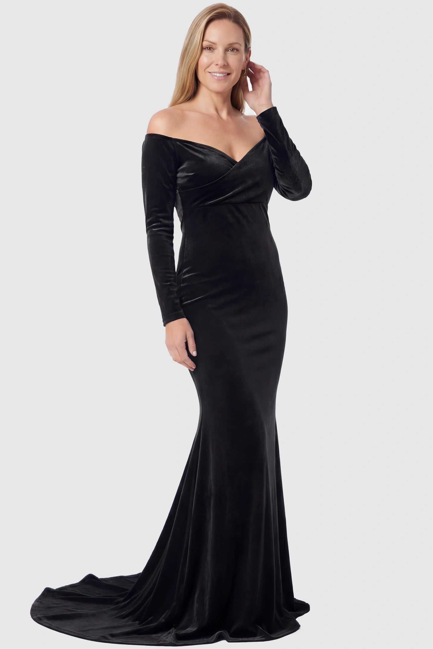 Velvet Long Fitted Sleeve Maternity Gown Velvet Long Fitted Sleeve Maternity Gown in black featuring an off-shoulder sweetheart neckline, draped bust, empire waist, and mermaid skirt on non pregnant model.
