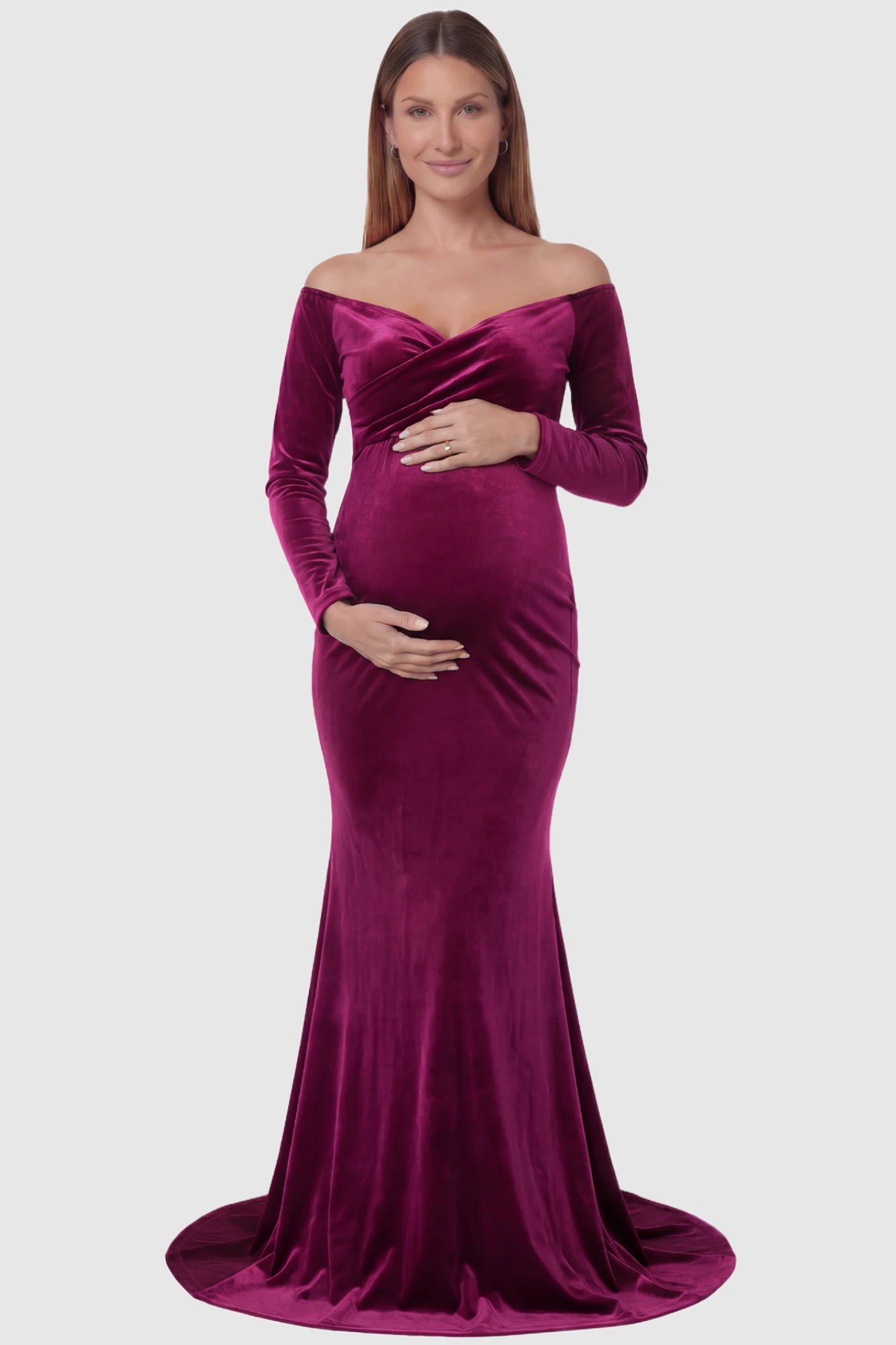 Velvet Long Fitted Sleeve Maternity Gown Velvet Long Fitted Sleeve Maternity Gown in burgundy featuring an off-shoulder sweetheart neckline, draped bust, empire waist, and mermaid skirt on pregnant model front view.
