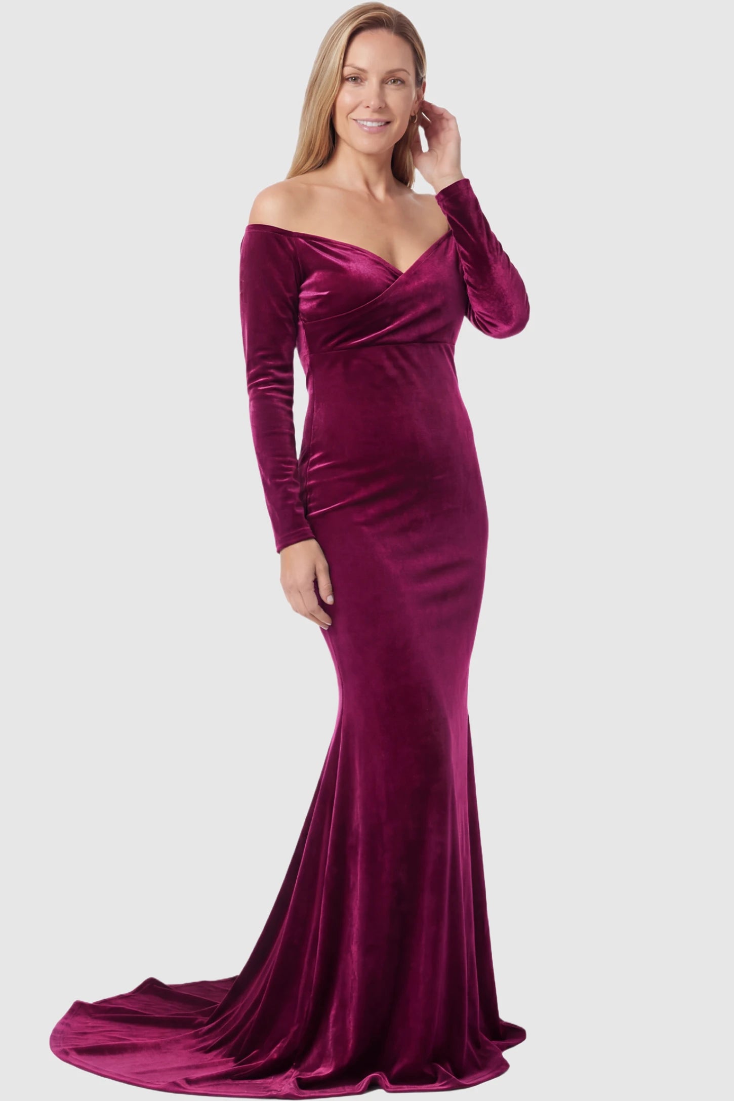 Velvet Long Fitted Sleeve Maternity Gown Velvet Long Fitted Sleeve Maternity Gown in burgundy featuring an off-shoulder sweetheart neckline, draped bust, empire waist, and mermaid skirt on non pregnant model.