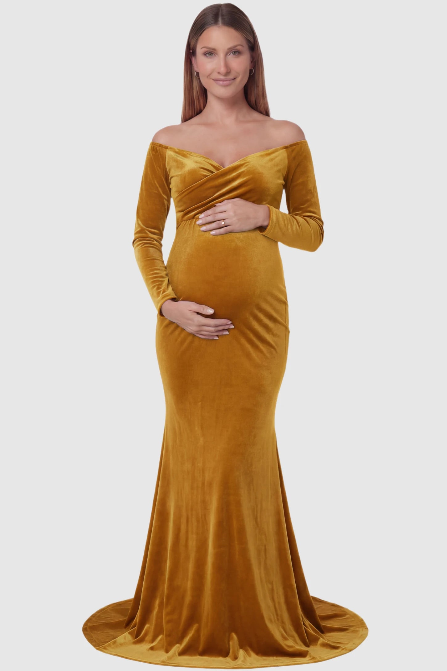 Velvet Long Fitted Sleeve Maternity Gown Velvet Long Fitted Sleeve Maternity Gown in gold featuring an off-shoulder sweetheart neckline, draped bust, empire waist, and mermaid skirt on pregnant model front view.