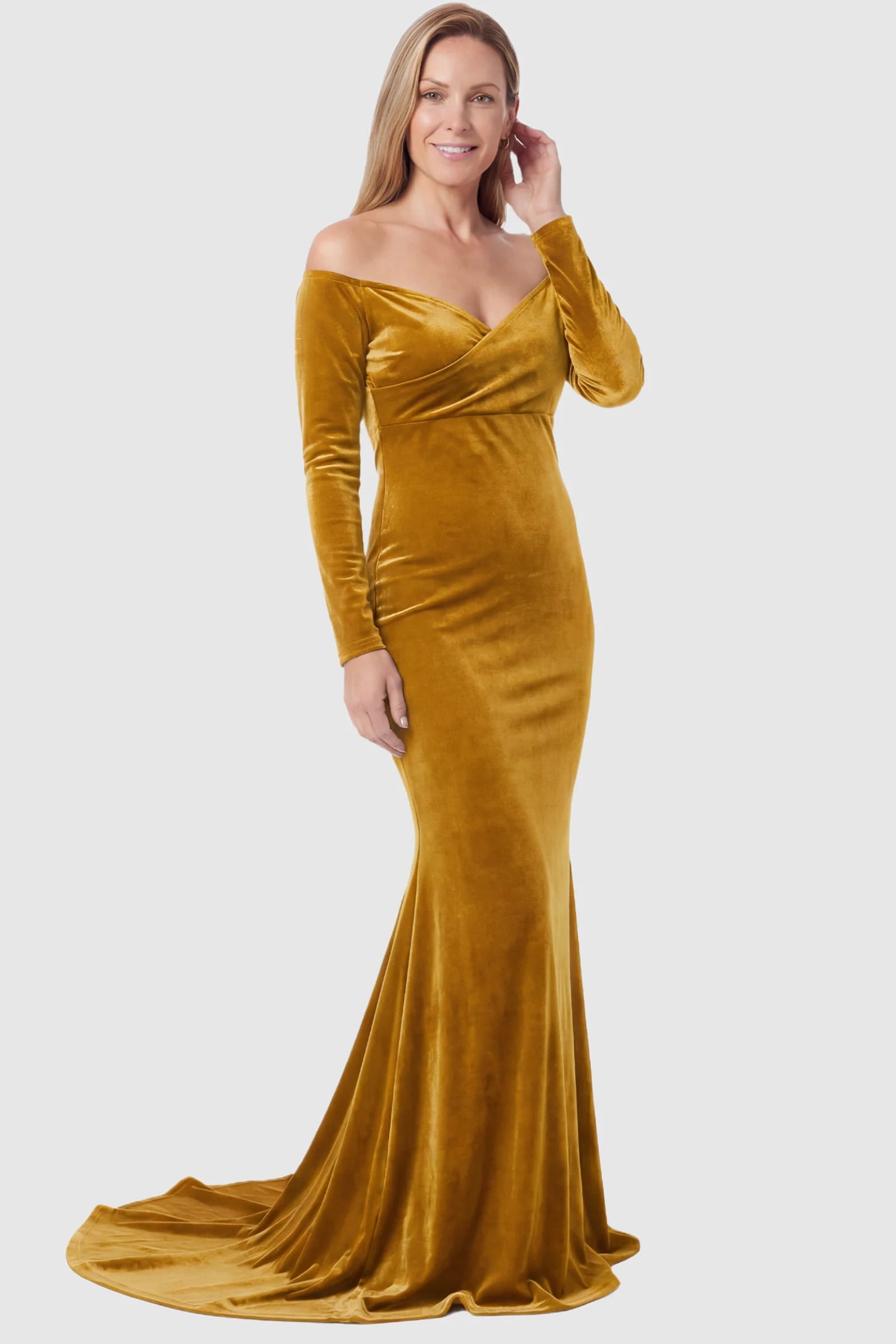 Velvet Long Fitted Sleeve Maternity Gown Velvet Long Fitted Sleeve Maternity Gown in gold featuring an off-shoulder sweetheart neckline, draped bust, empire waist, and mermaid skirt on non pregnant model.