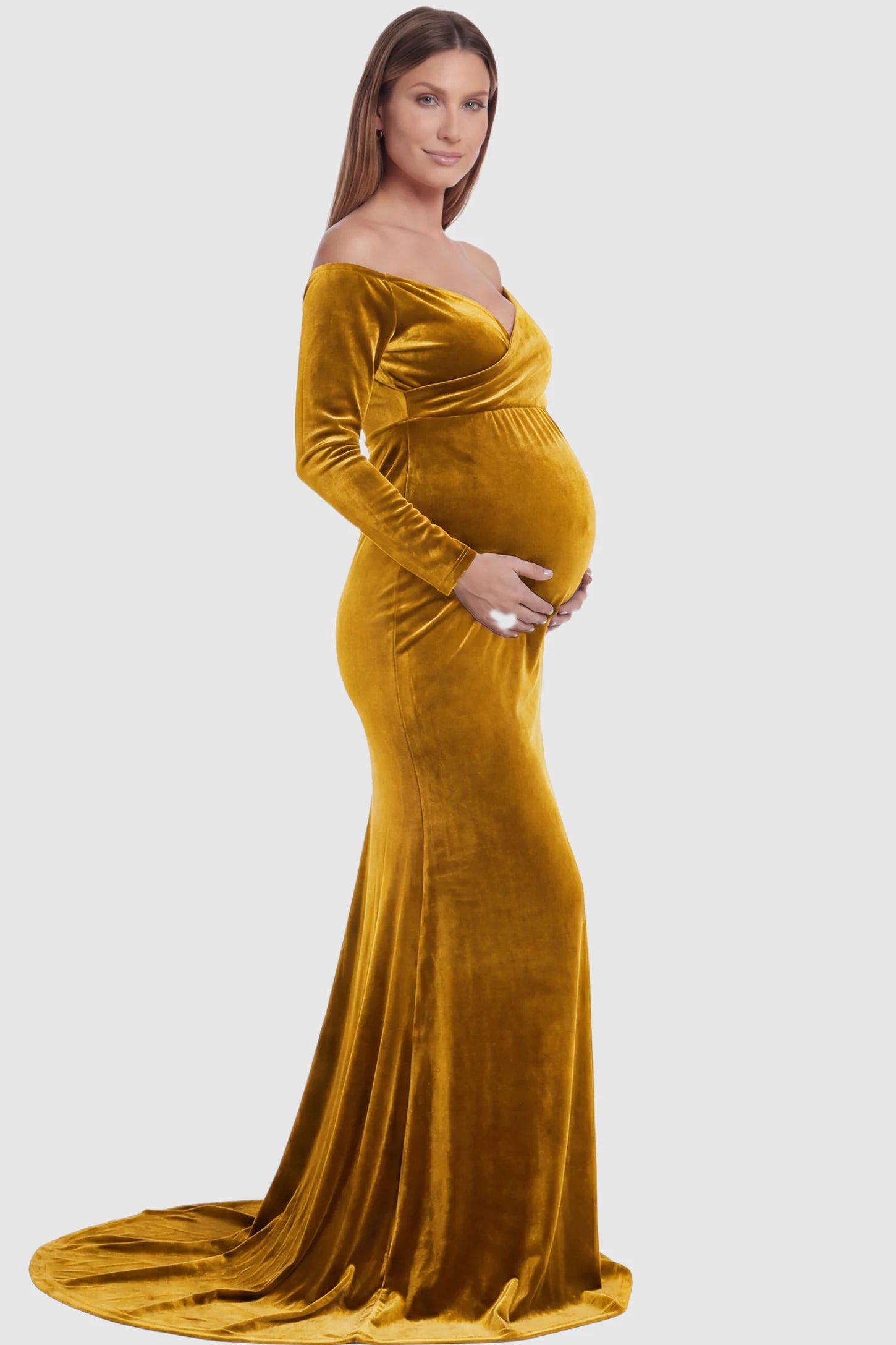 Velvet Long Fitted Sleeve Maternity Gown Velvet Long Fitted Sleeve Maternity Gown in gold featuring an off-shoulder sweetheart neckline, draped bust, empire waist, and mermaid skirt on pregnant model side view.
