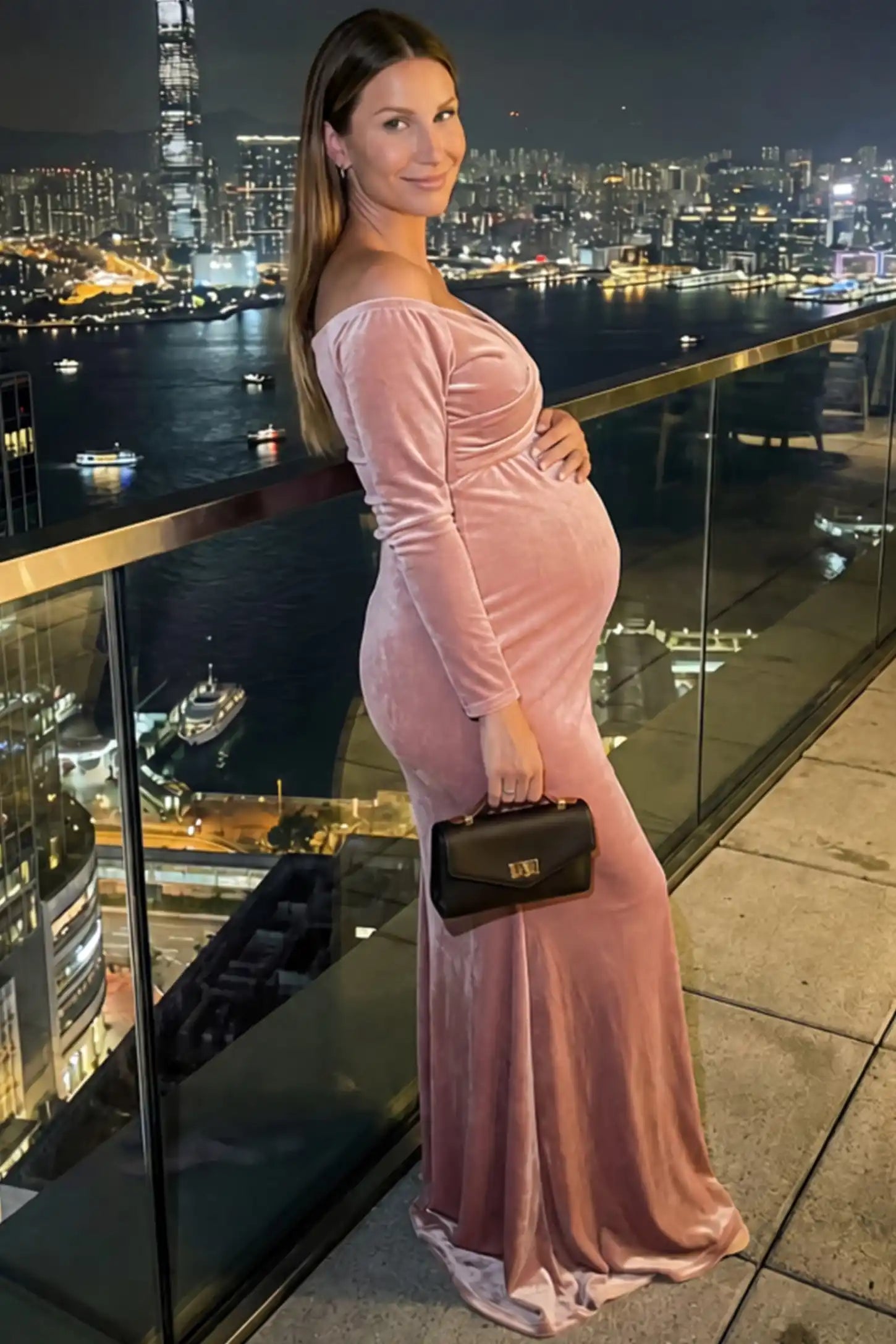 Velvet Long Fitted Sleeve Maternity Gown in pink featuring an off-shoulder sweetheart neckline, draped bust, empire waist, and mermaid skirt on pregnant model.