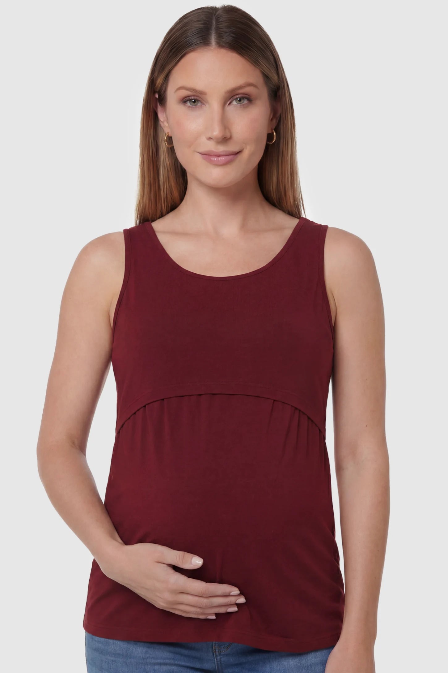 Basic Maternity & Nursing Tank Top Basic Maternity & Nursing Tank Top in burgundy featuring a scoop neck and smooth, body-hugging fit on a pregnant model, front view.