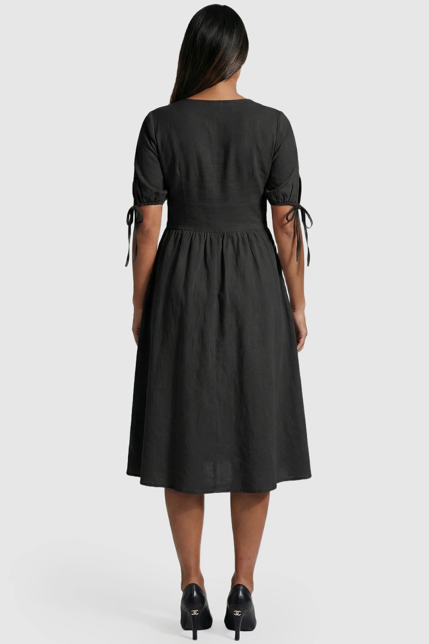 Tie-Sleeve V-Neck Flared Maternity Midi Dress Tie-Sleeve V-Neck Flared Maternity Midi Dress in Black featuring short puff sleeves on a pregnant model.