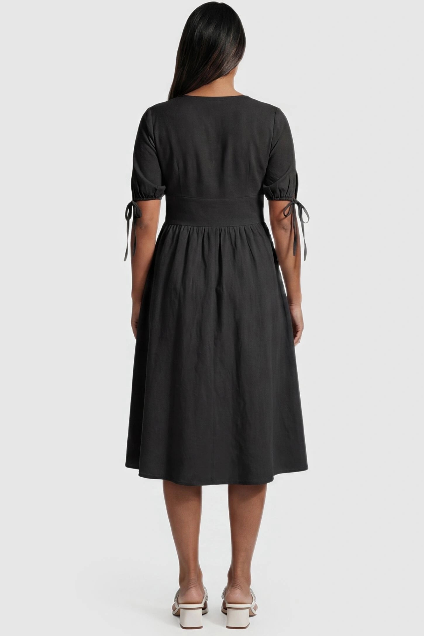 Tie-Sleeve V-Neck Flared Maternity Midi Dress Back view Tie-Sleeve V-Neck Flared Maternity Midi Dress in Black featuring a flared skirt on a non-pregnant model.