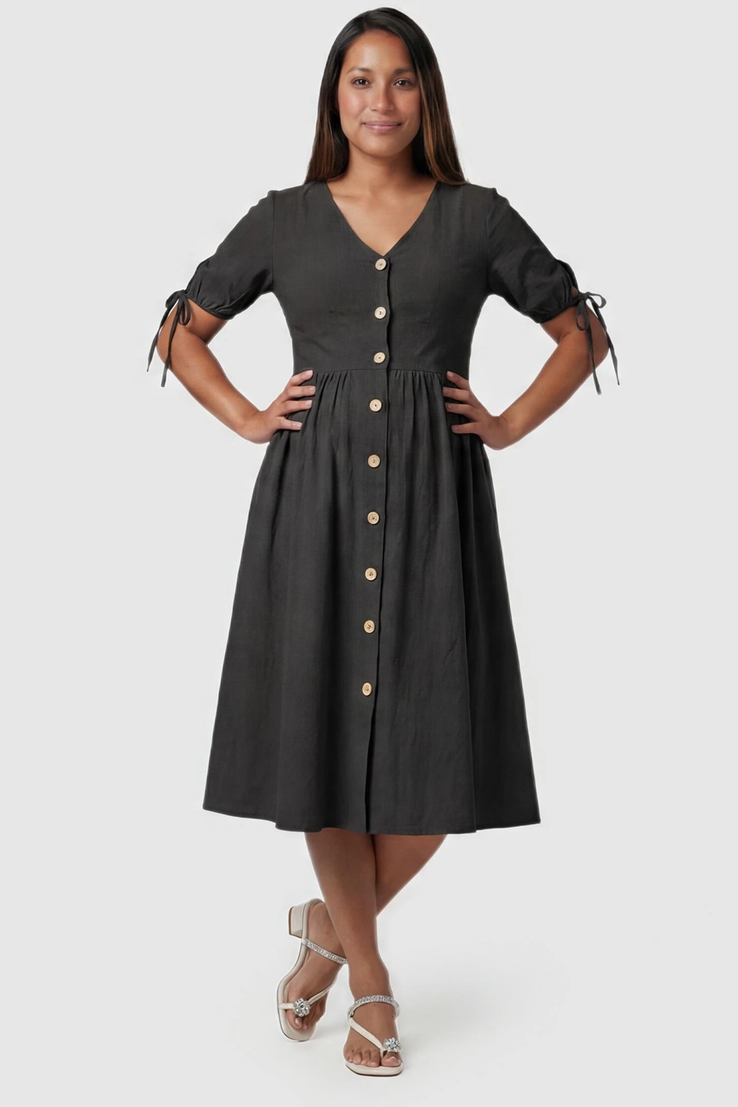 Tie-Sleeve V-Neck Flared Maternity Midi Dress Front view Tie-Sleeve V-Neck Flared Maternity Midi Dress in Black featuring a button front on a pregnant model.