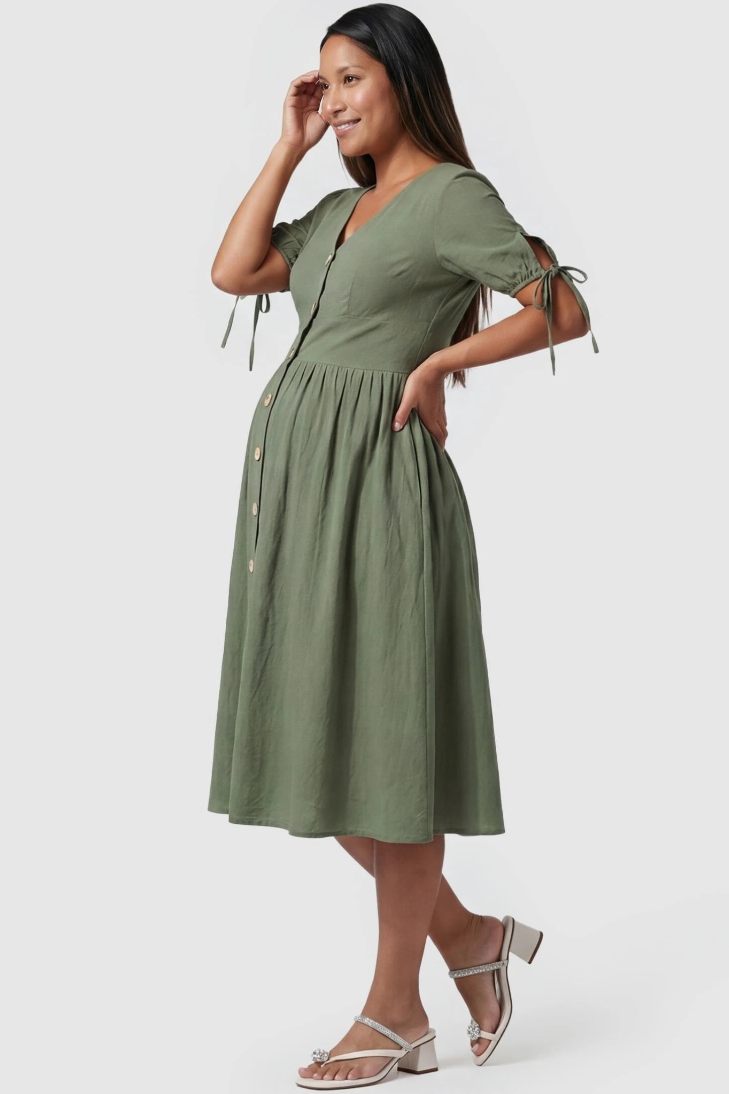 Tie-Sleeve V-Neck Flared Maternity Midi Dress Side view Tie-Sleeve V-Neck Flared Maternity Midi Dress in Green featuring an empire waist on a pregnant model.