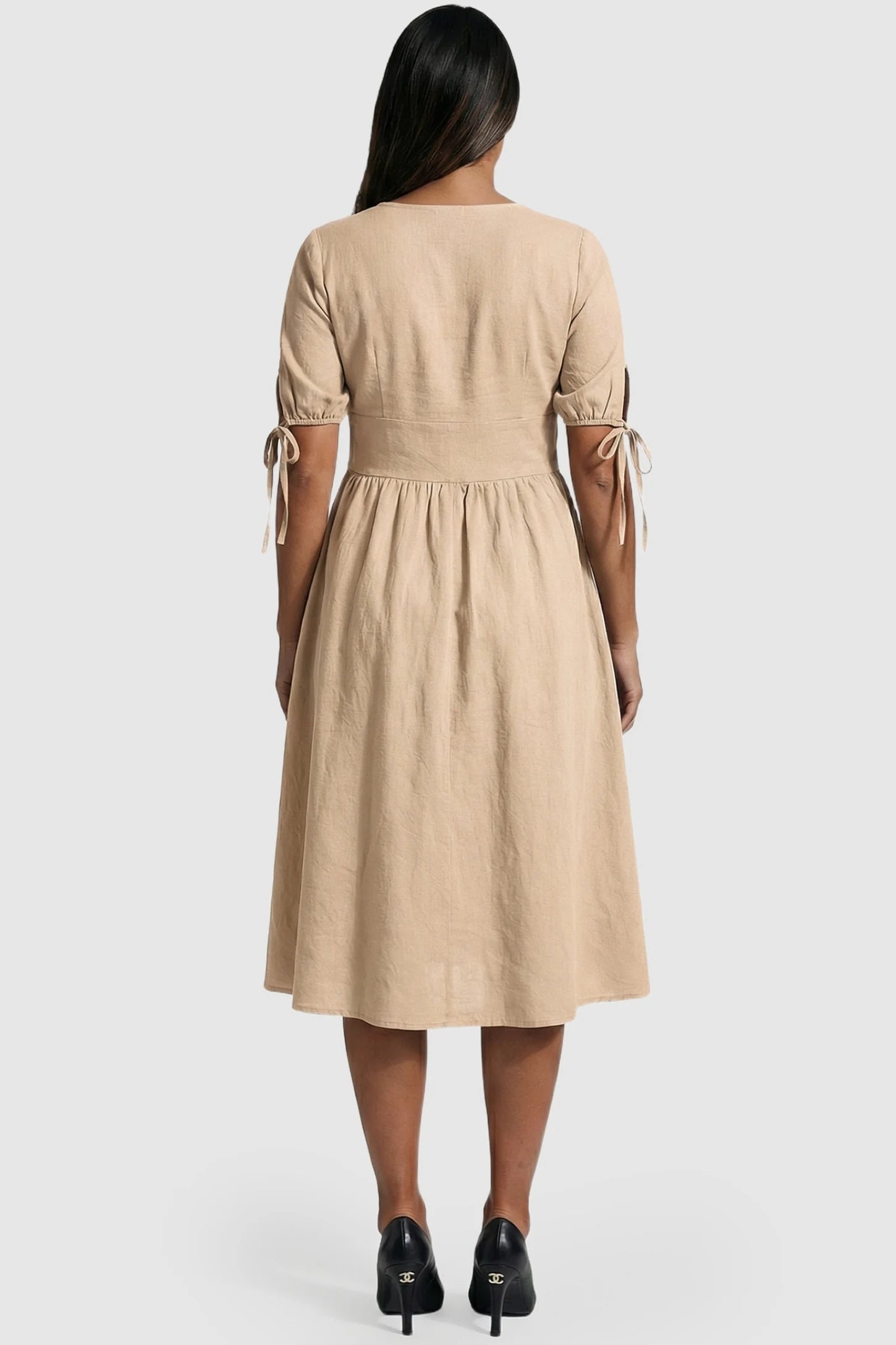 Tie-Sleeve V-Neck Flared Maternity Midi Dress Tie-Sleeve V-Neck Flared Maternity Midi Dress in Apricot featuring puff sleeves with ties on a pregnant model.