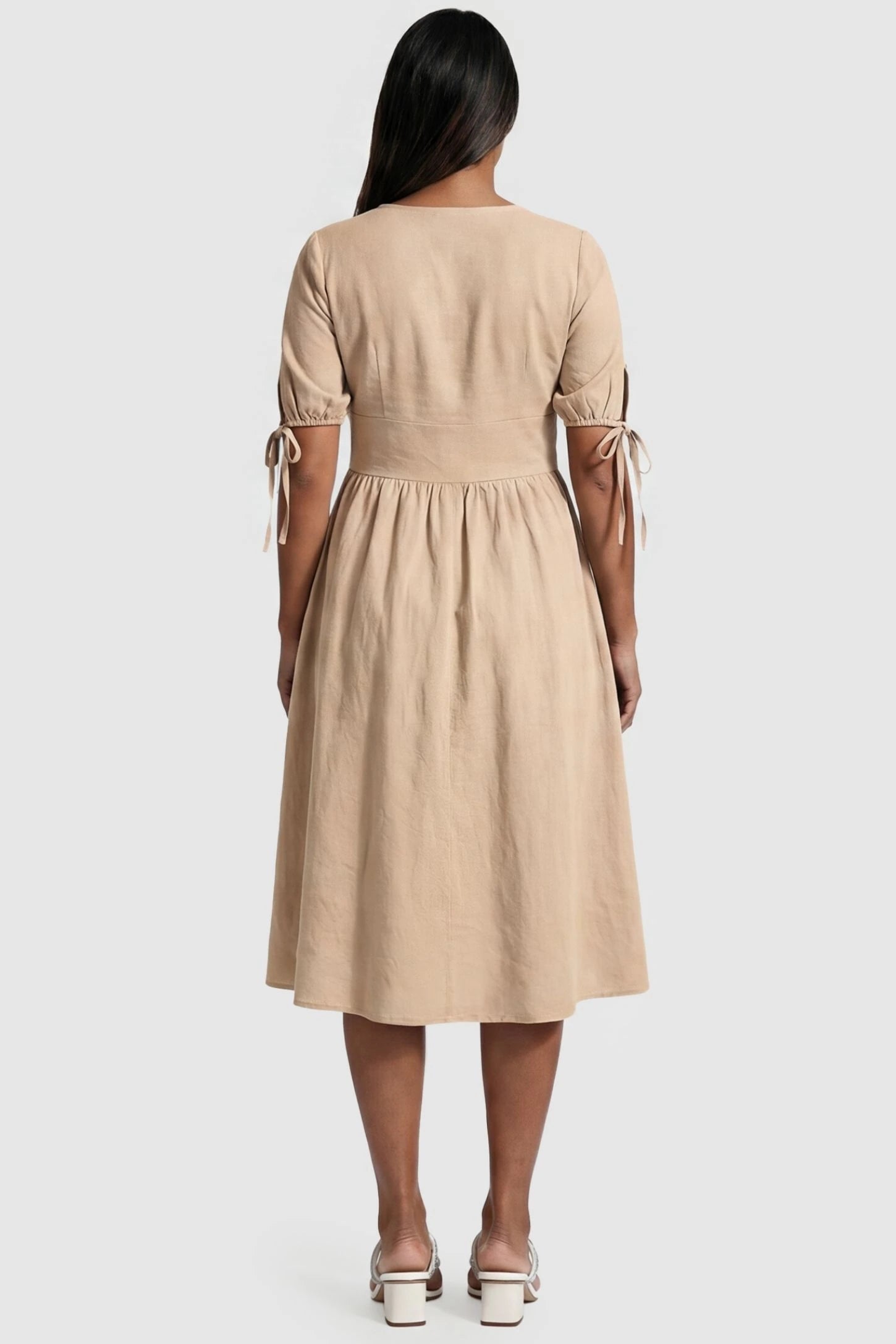 Tie-Sleeve V-Neck Flared Maternity Midi Dress Editorial view Tie-Sleeve V-Neck Flared Maternity Midi Dress in Apricot featuring tie-sleeves on a pregnant model.