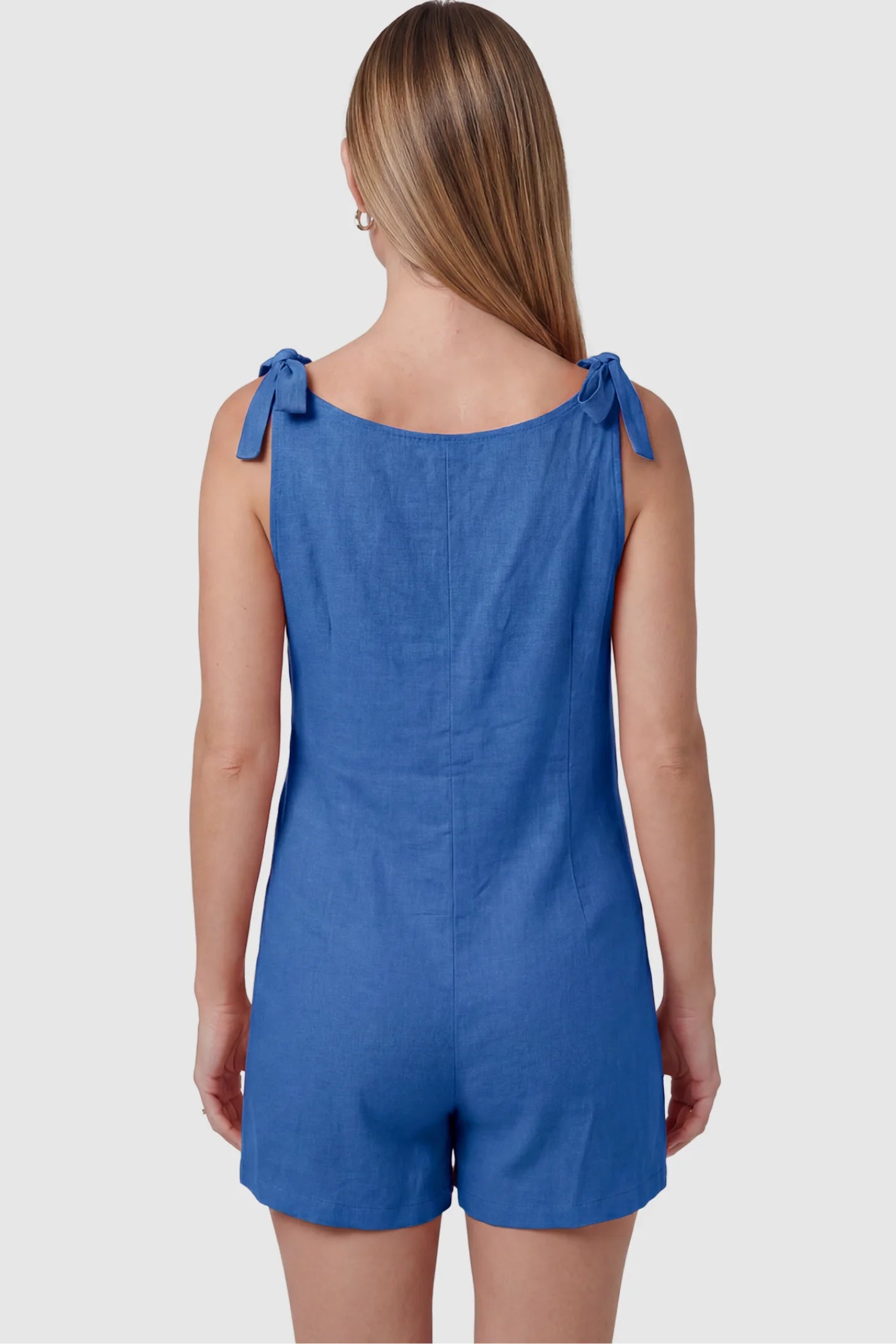 Tie-Strap Sleeveless Pocketed Maternity Romper Tie-strap sleeveless pocketed maternity romper in blue with adjustable tie straps, back view on pregnant model