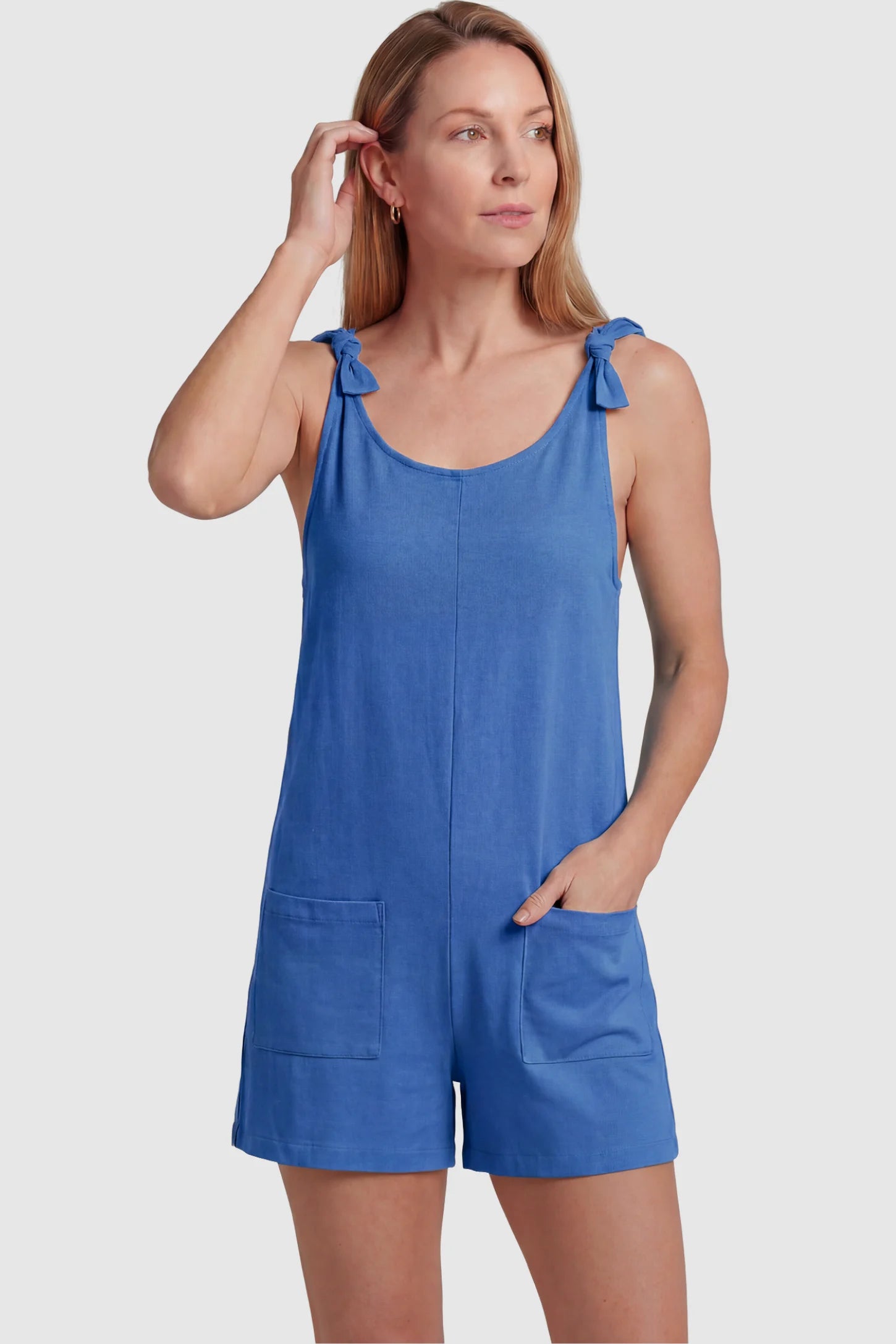 Tie-Strap Sleeveless Pocketed Maternity Romper Tie-strap sleeveless pocketed maternity romper in blue with adjustable tie straps and scoop neckline, front view on postpartum model