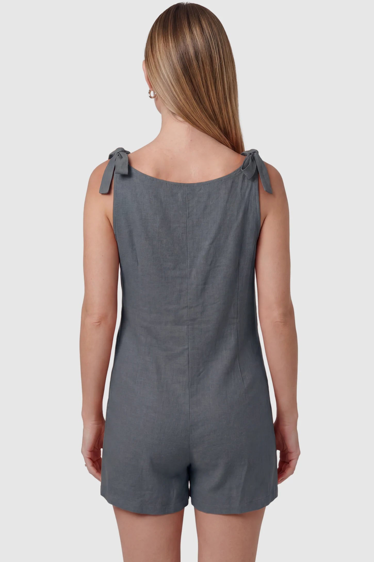 Tie-Strap Sleeveless Pocketed Maternity Romper Tie-strap sleeveless pocketed maternity romper in gray with adjustable tie straps, back view on pregnant model