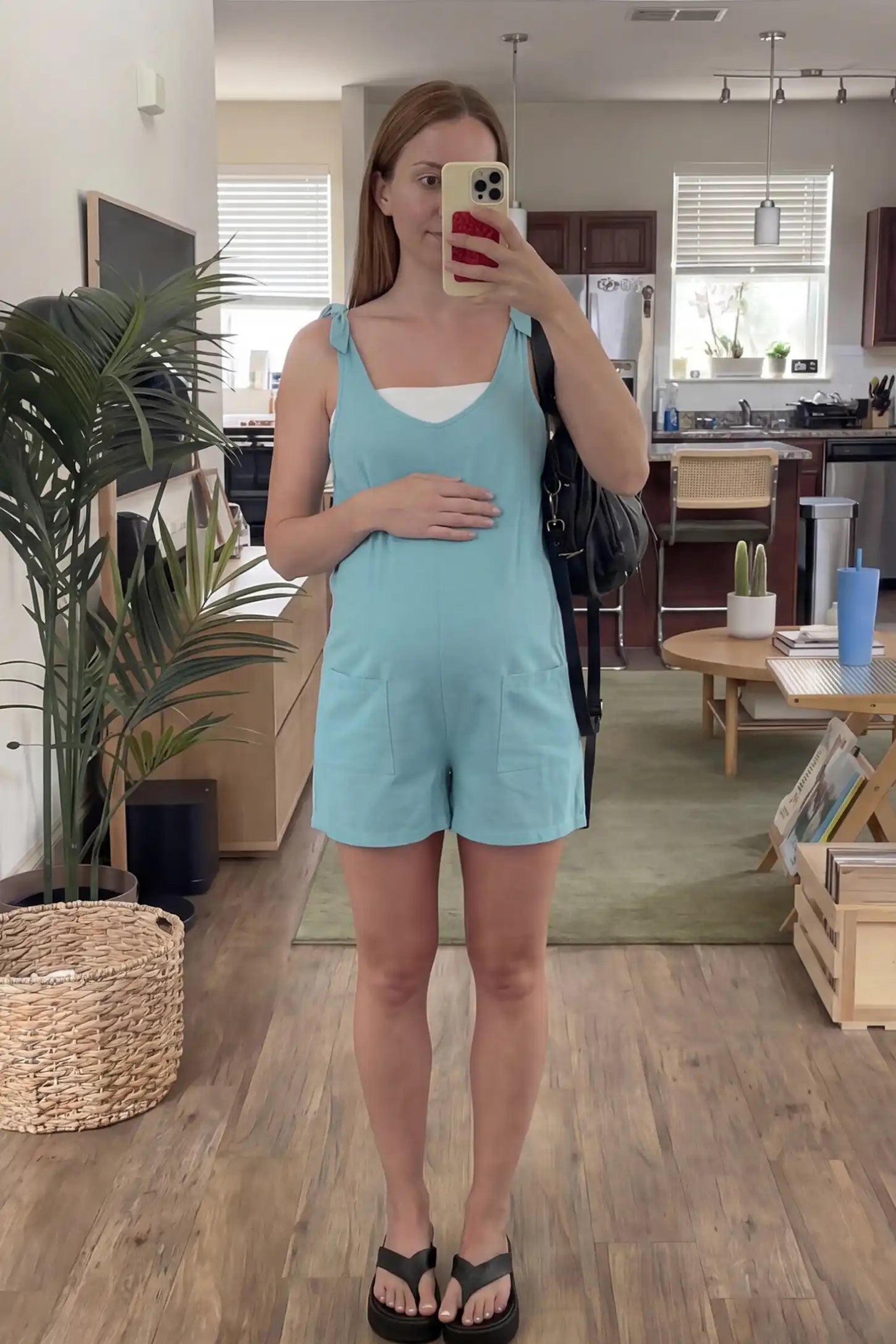 Tie-Strap Sleeveless Pocketed Maternity Romper Tie-strap sleeveless pocketed maternity romper in sky blue with adjustable tie straps and scoop neckline, front view on pregnant model