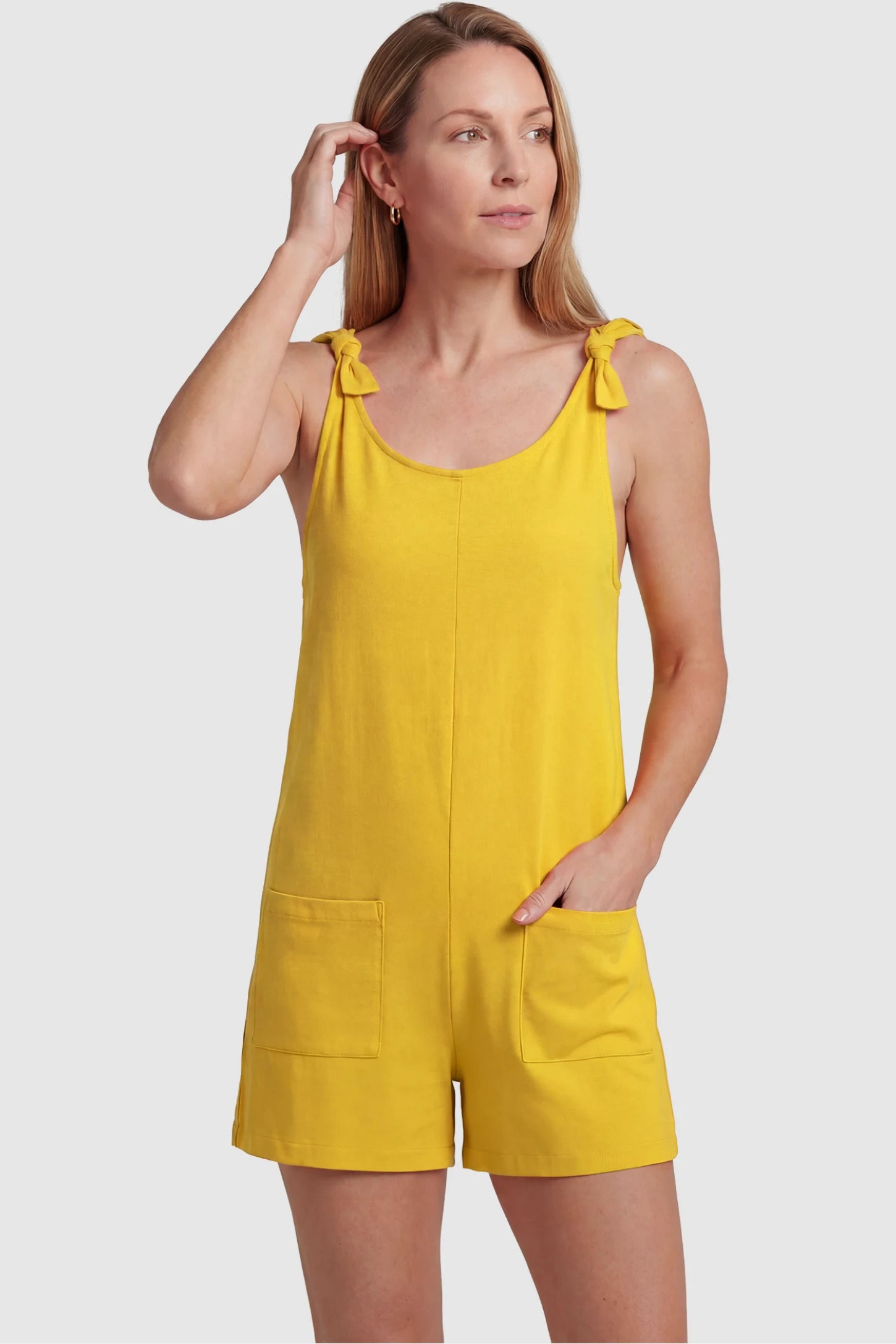 Tie-Strap Sleeveless Pocketed Maternity Romper Tie-strap sleeveless pocketed maternity romper in yellow with adjustable tie straps and scoop neckline, front view on postpartum model
