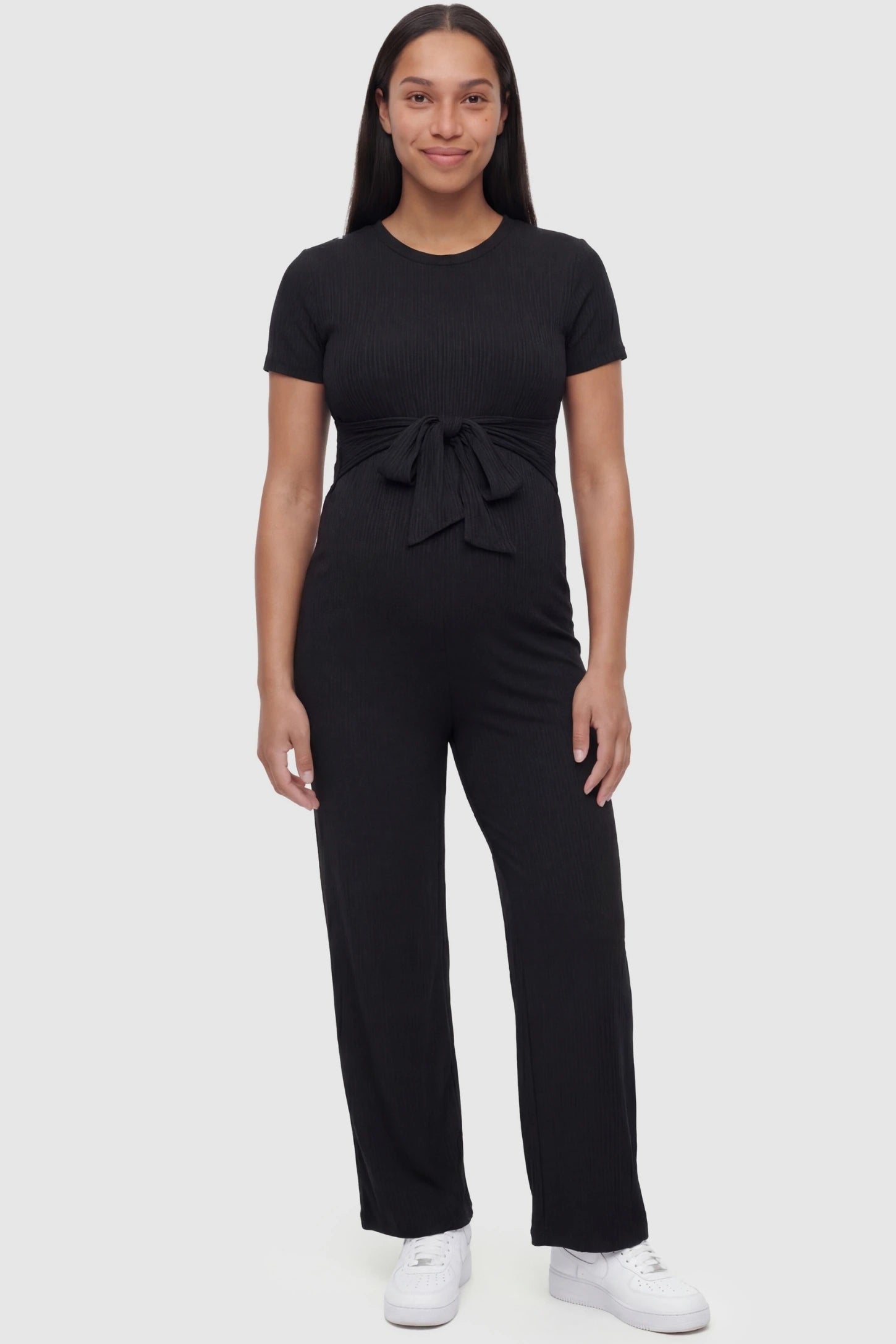 Round Neck Paperbag Waist Maternity Jumpsuit in Black featuring a tie waist on a pregnant model.