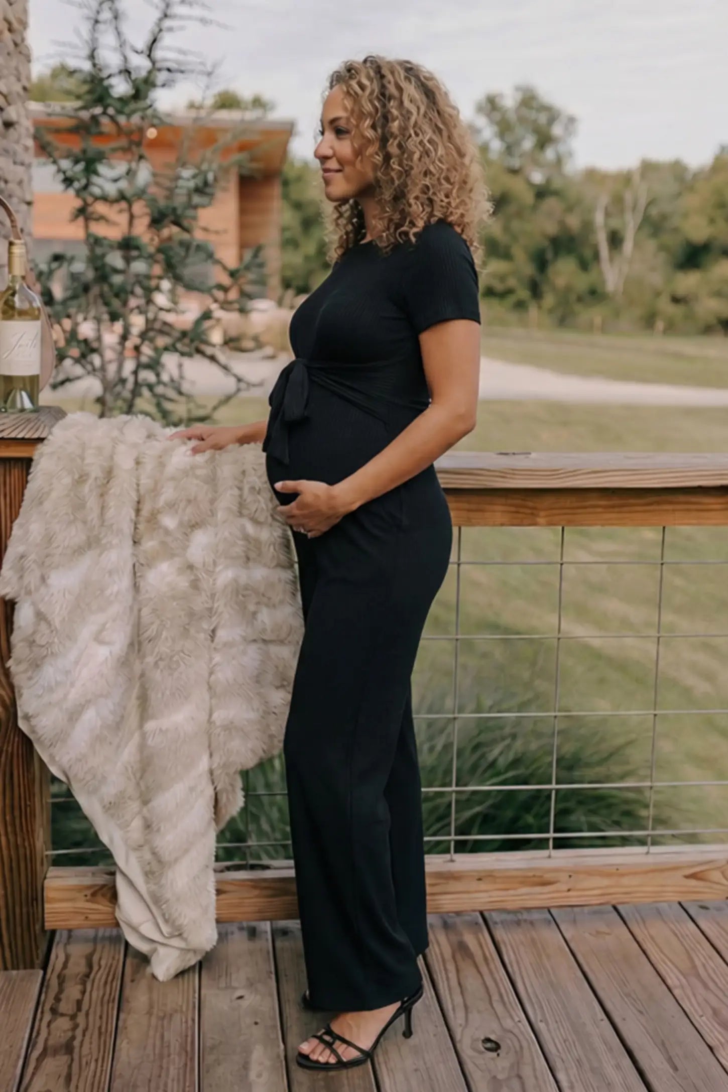 Round Neck Paperbag Waist Maternity Jumpsuit Round Neck Paperbag Waist Maternity Jumpsuit in Black featuring a tie waist on a pregnant model.