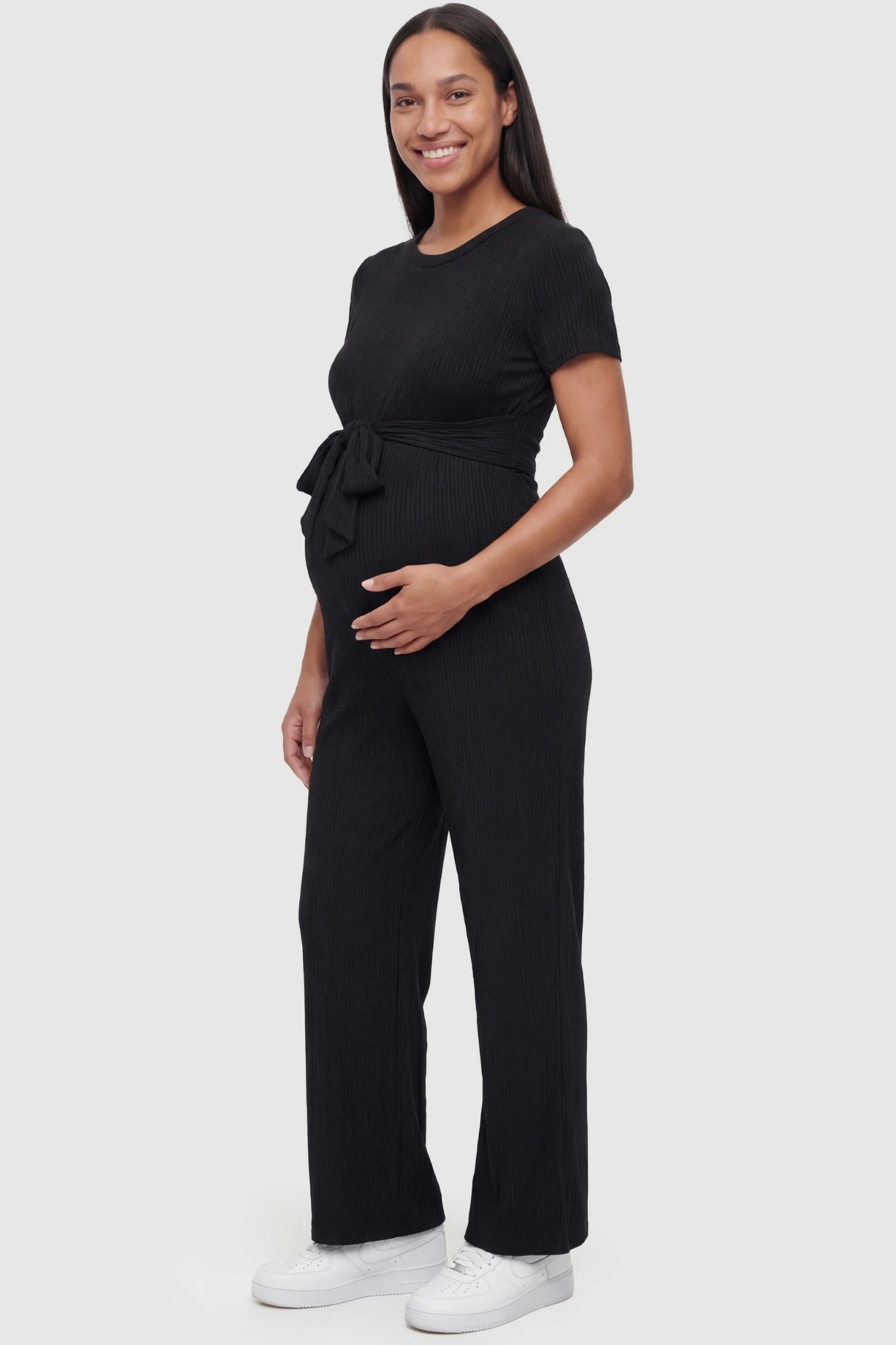 Round Neck Paperbag Waist Maternity Jumpsuit in Black featuring a tie waist on a pregnant model.