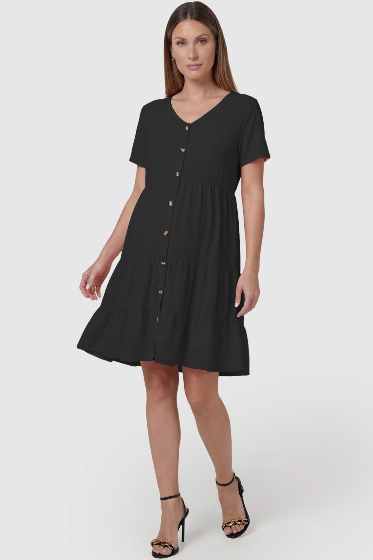 Tiered Button-Front A-Line Maternity Summer Dress Tiered Button-Front A-Line Maternity Summer Dress in Black featuring a sculpted V-neck on a pregnant model, front view.
