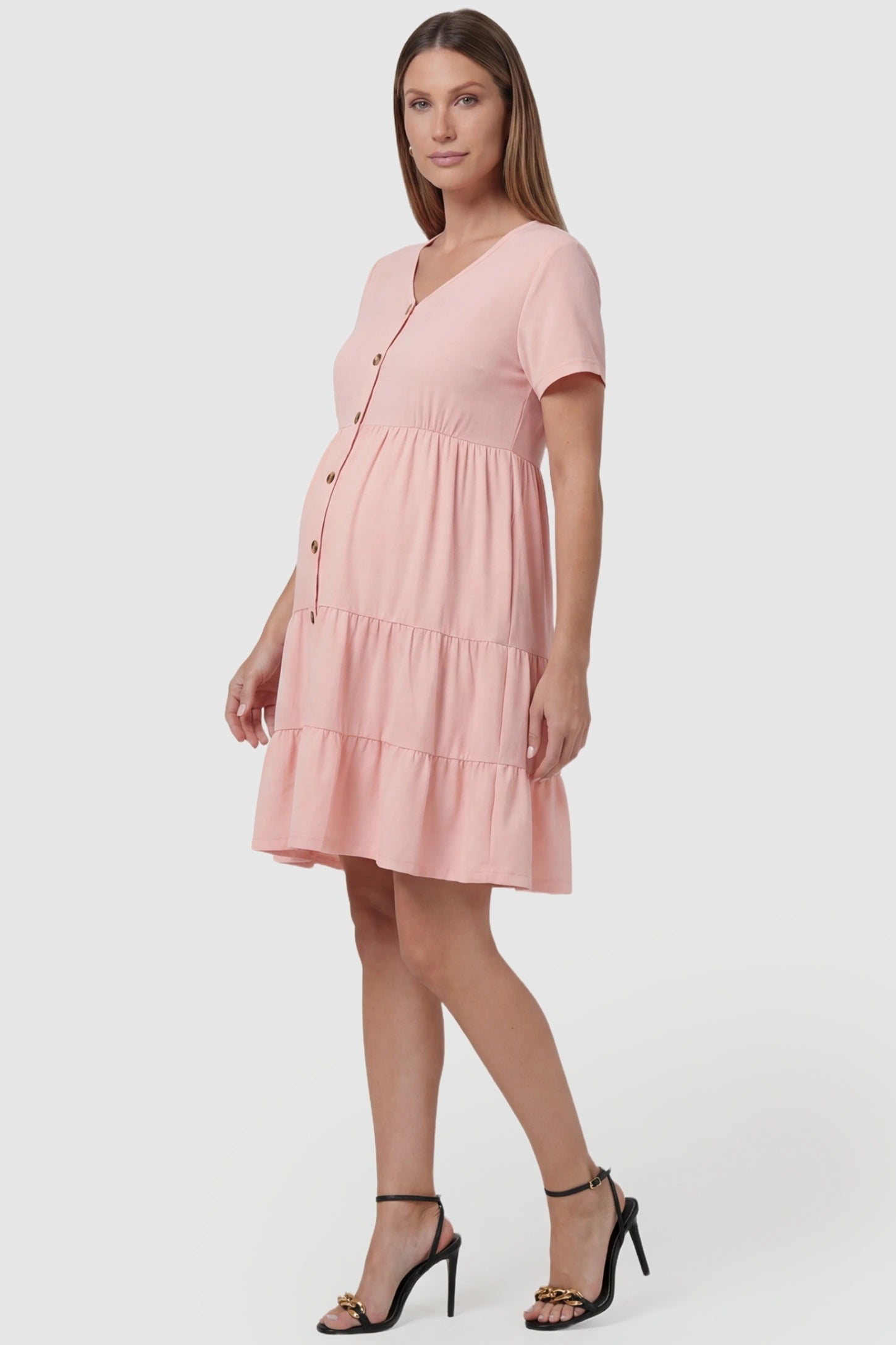 Tiered Button-Front A-Line Maternity Summer Dress in Pink featuring wood-style buttons on a pregnant model, side view.