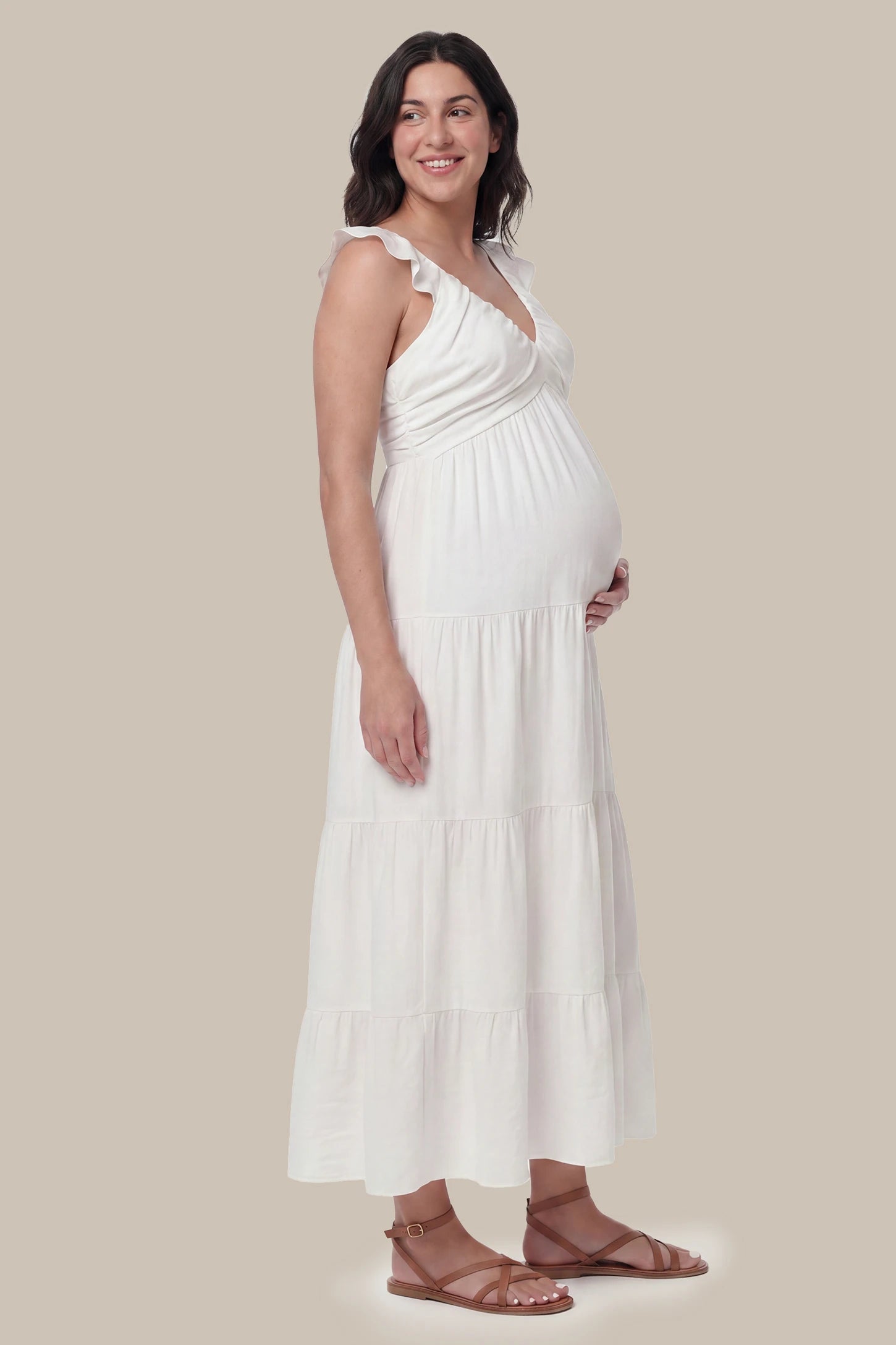 Ruffled Sleeve V-neck A-line Maternity Midi Dress Ruffled sleeve V-neck A-line maternity midi dress in off-white with ruffled sleeves and tiered skirt, side view on pregnant model