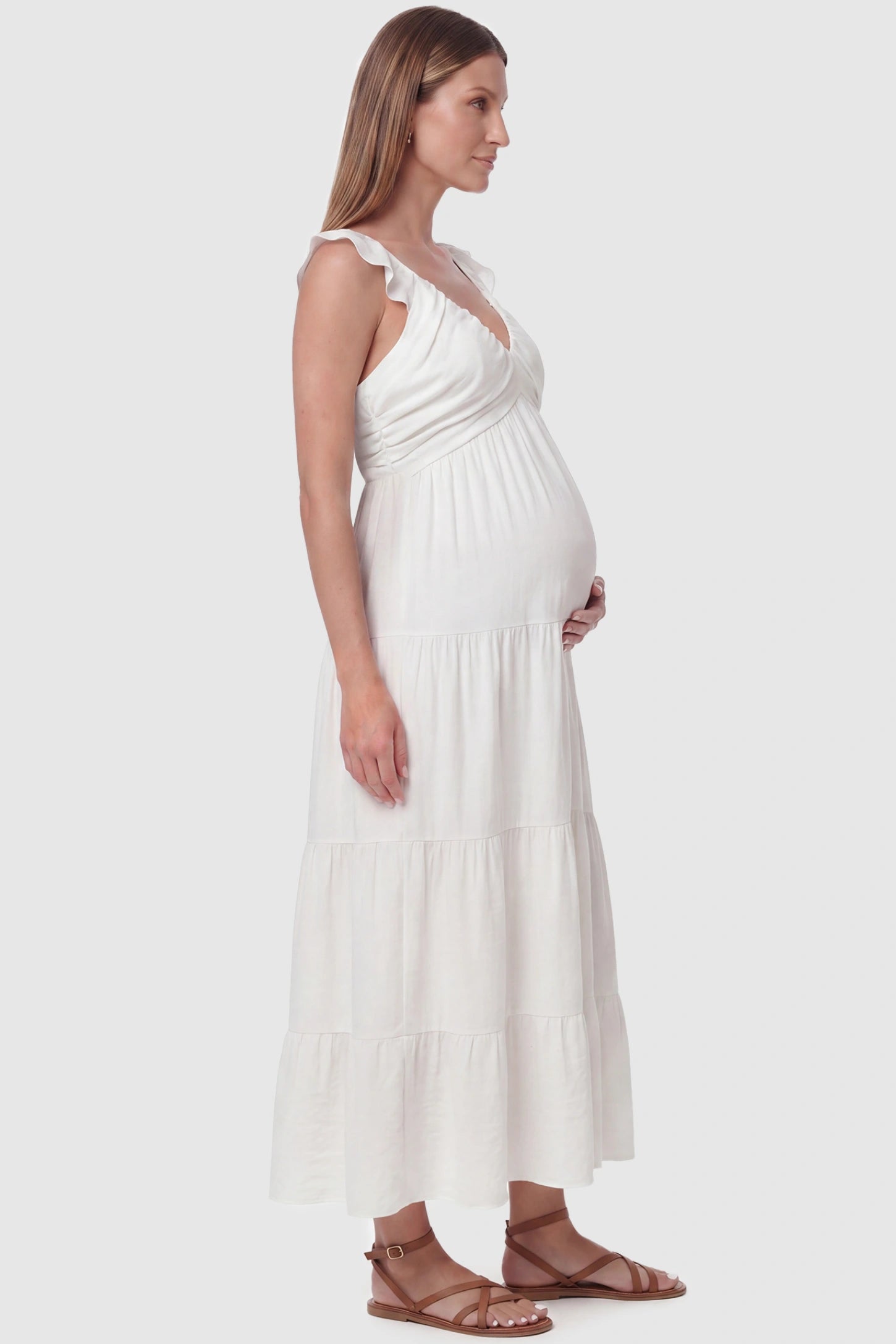 Ruffled Sleeve V-neck A-line Maternity Midi Dress Ruffled sleeve V-neck A-line maternity midi dress in off-white with ruffled sleeves and tiered skirt, side view on pregnant model
