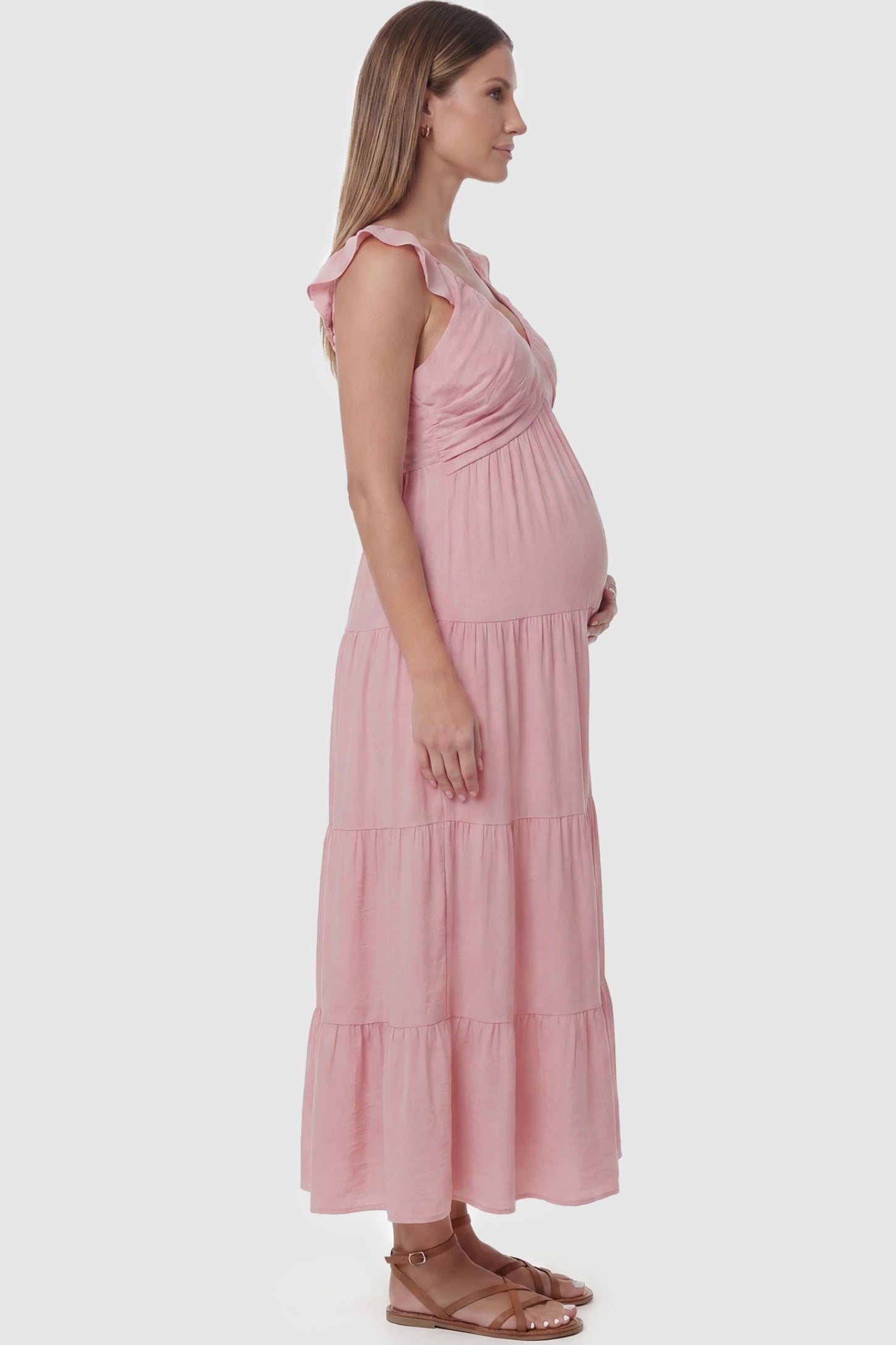 Ruffled Sleeve V-neck A-line Maternity Midi Dress Ruffled sleeve V-neck A-line maternity midi dress in pink with ruffled sleeves and tiered skirt, side view on pregnant model