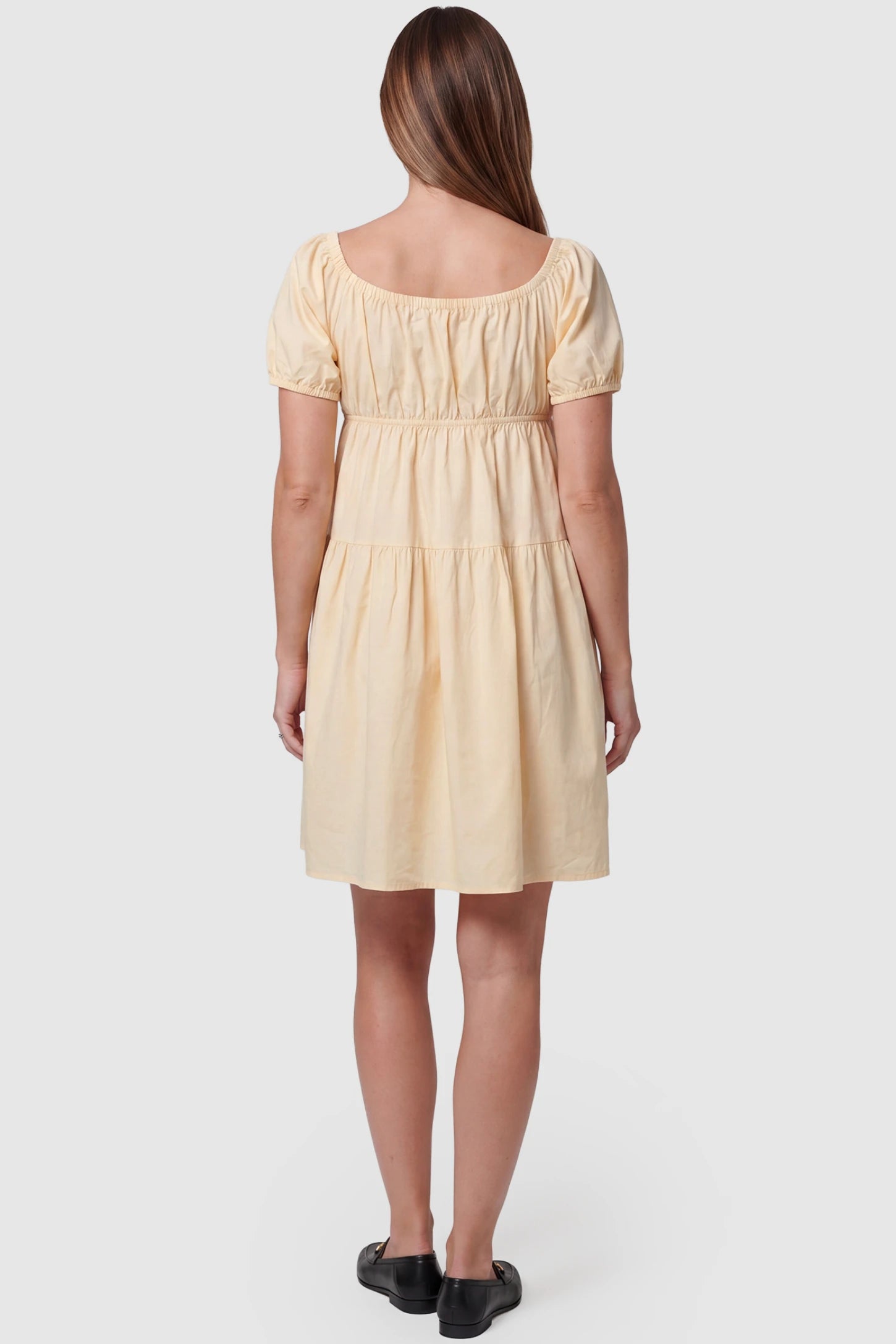Short Sleeve Tiered A-Line Maternity Short Dress Short sleeve tiered A-line maternity short dress in yellow with elegant short sleeves, back view on pregnant model
