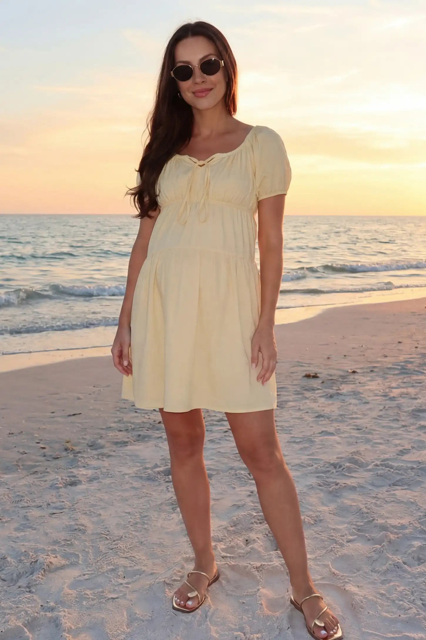 Short Sleeve Tiered A-Line Maternity Short Dress Short sleeve tiered A-line maternity short dress in yellow with bump-flattering A-line fit, front view on pregnant model