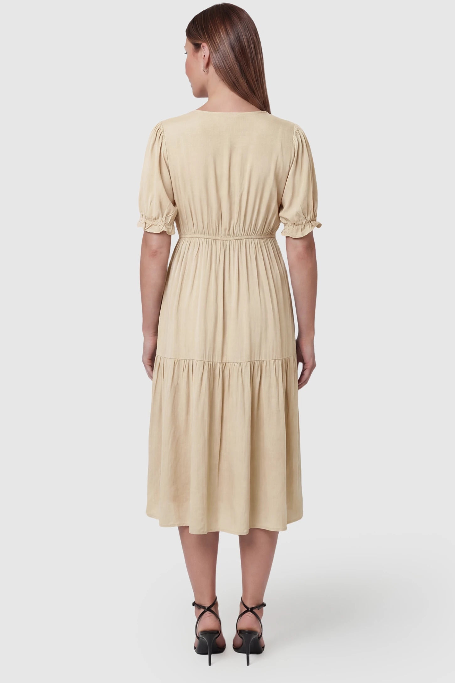 Tiered Hem A-Line Maternity Midi Dress Tiered Hem A-Line Maternity Midi Dress in apricot featuring empire waist, elbow-length puff sleeves, V-neckline, and flowy skirt on pregnant model. back view