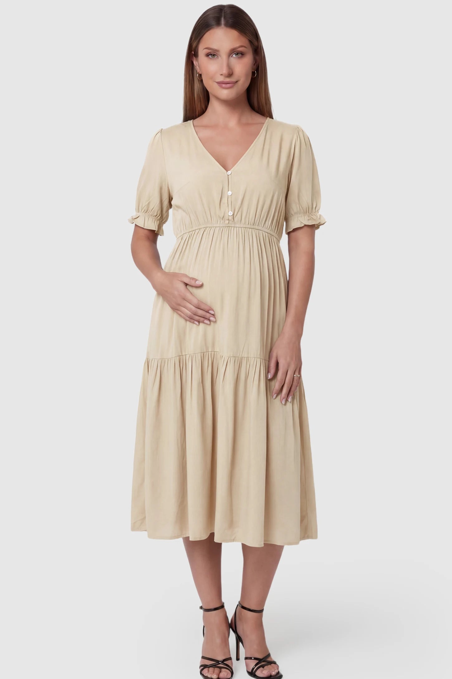Tiered Hem A-Line Maternity Midi Dress Tiered Hem A-Line Maternity Midi Dress in apricot featuring empire waist, elbow-length puff sleeves, V-neckline, and flowy skirt on pregnant model. front view