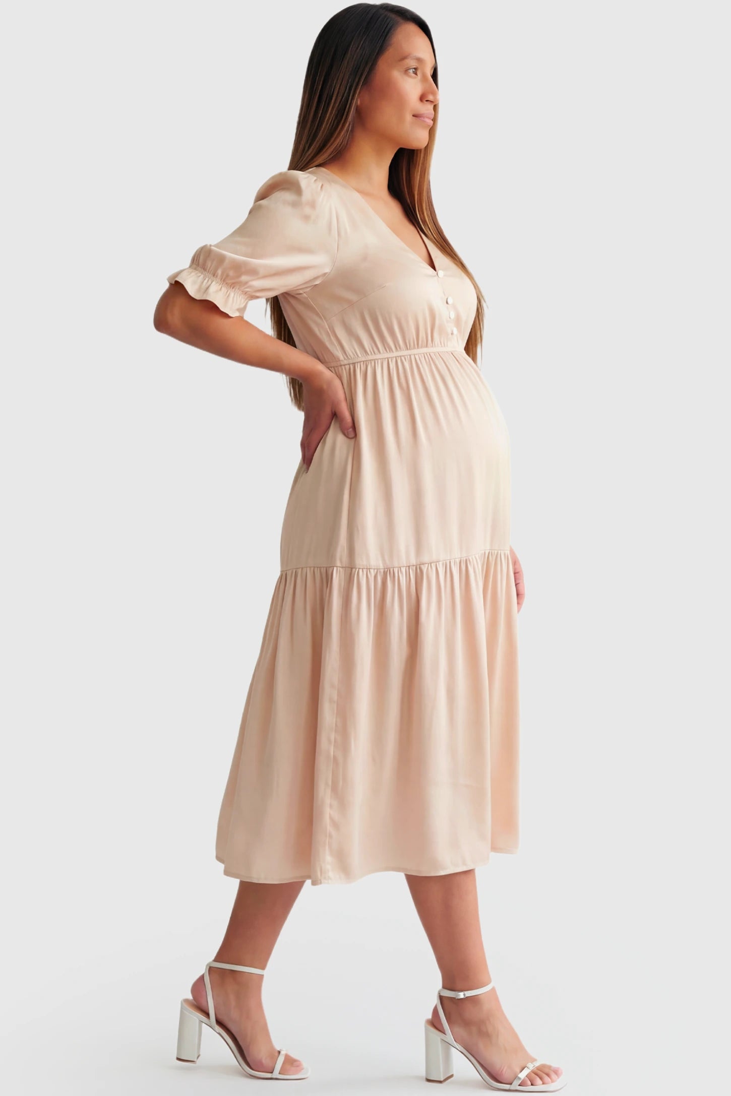 Tiered Hem A-Line Maternity Midi Dress Tiered Hem A-Line Maternity Midi Dress in apricot featuring empire waist, elbow-length puff sleeves, V-neckline, and flowy skirt on pregnant model.