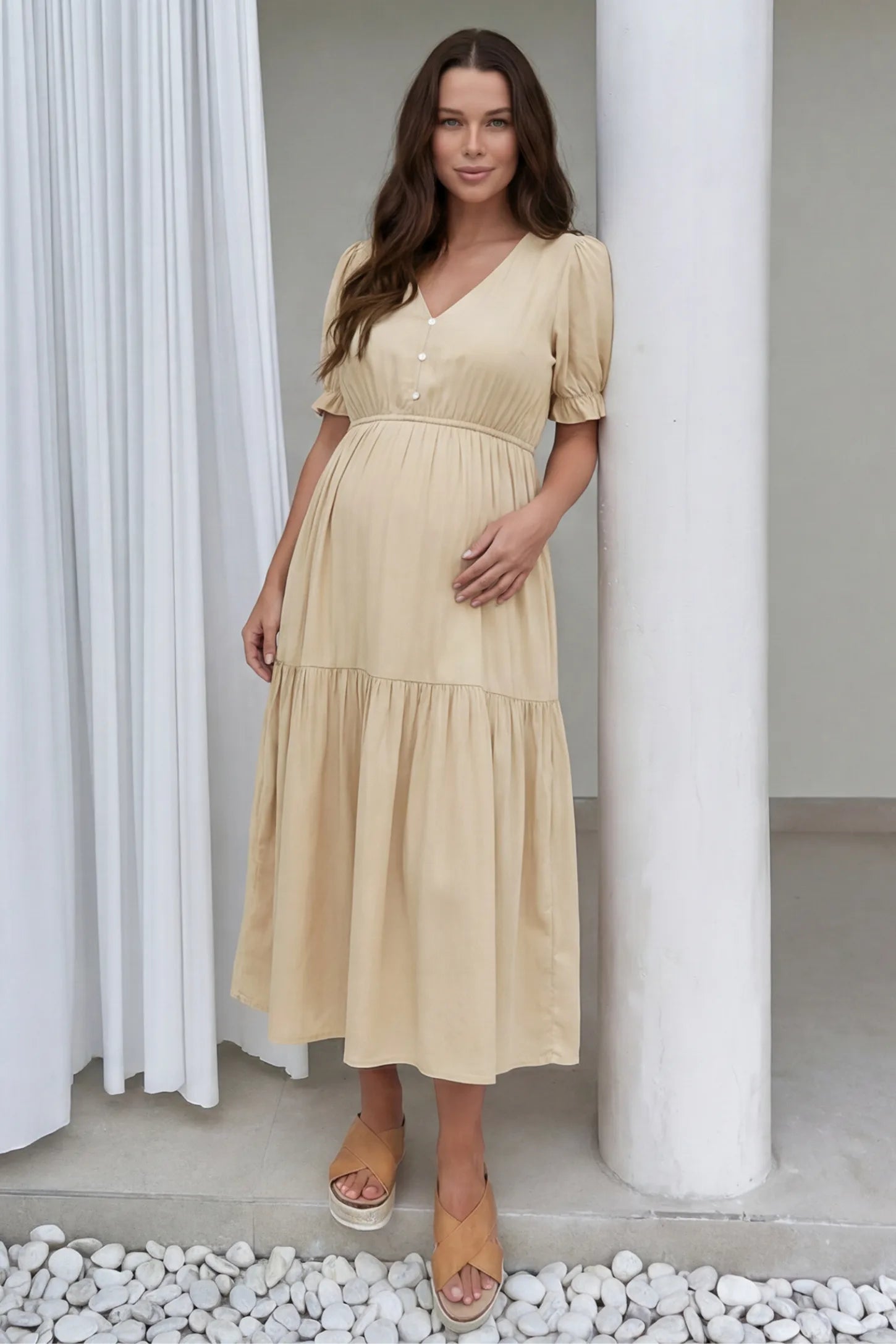 Tiered Hem A-Line Maternity Midi Dress Tiered Hem A-Line Maternity Midi Dress in apricot featuring empire waist, elbow-length puff sleeves, V-neckline, and flowy skirt on pregnant model.