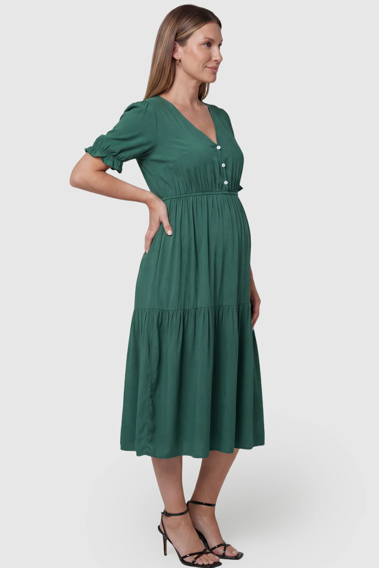 Tiered Hem A-Line Maternity Midi Dress Tiered Hem A-Line Maternity Midi Dress in army green featuring empire waist, elbow-length puff sleeves, V-neckline, and flowy skirt on pregnant model. side view