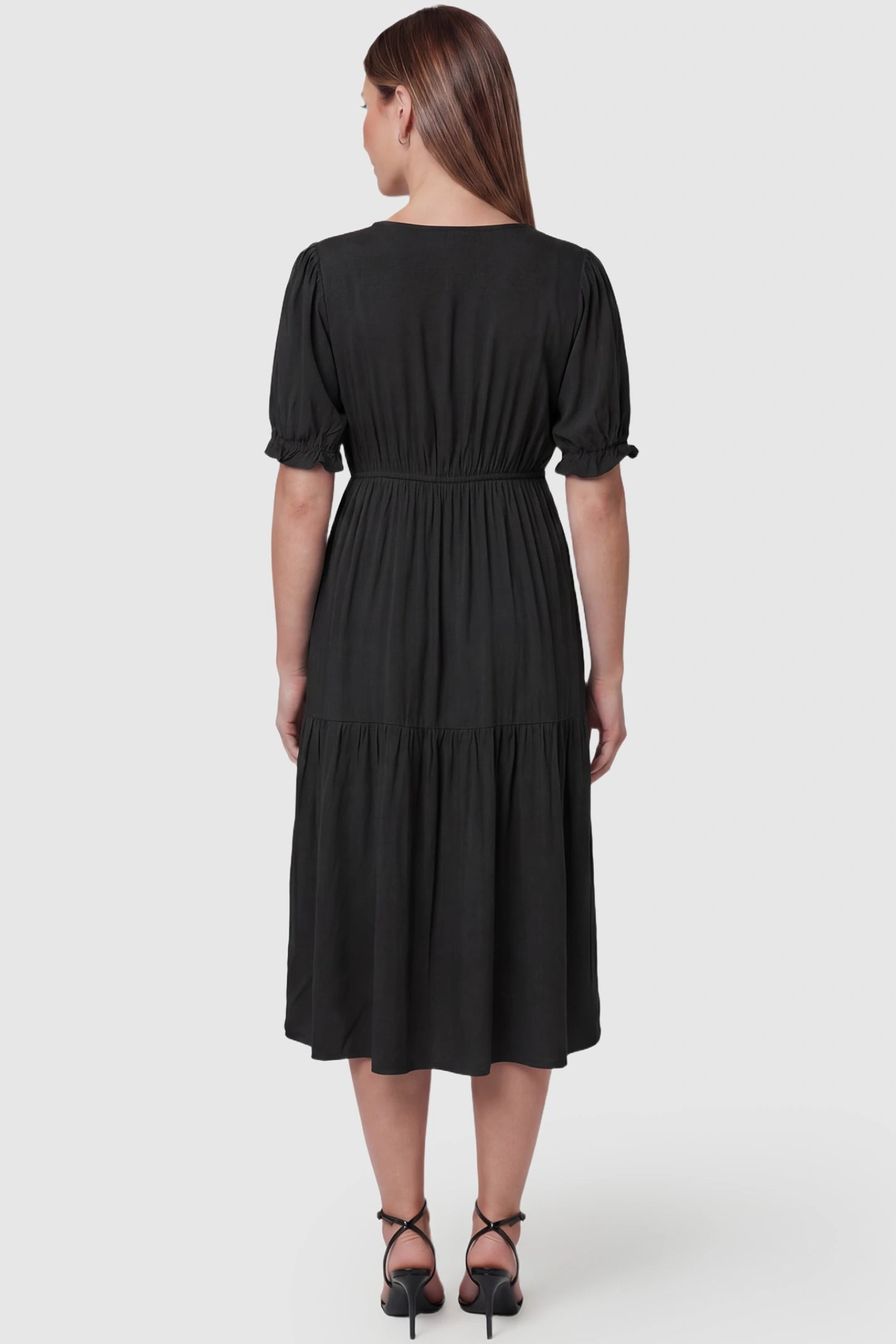 Tiered Hem A-Line Maternity Midi Dress  Tiered Hem A-Line Maternity Midi Dress in black featuring empire waist, elbow-length puff sleeves, V-neckline, and flowy skirt on pregnant model.  back view