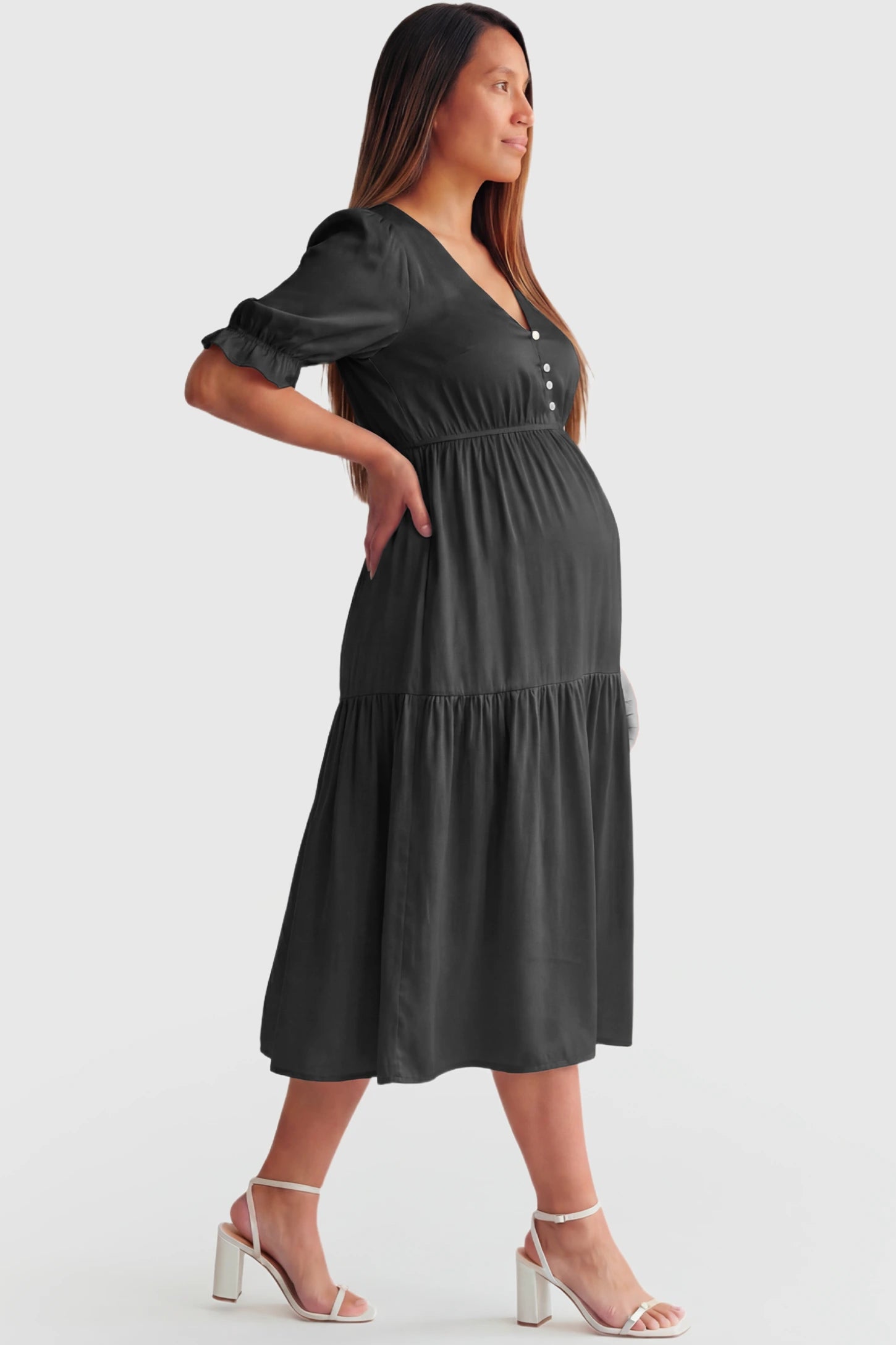 Tiered Hem A-Line Maternity Midi Dress Tiered Hem A-Line Maternity Midi Dress in apricot featuring empire waist, elbow-length puff sleeves, V-neckline, and flowy skirt on pregnant model.